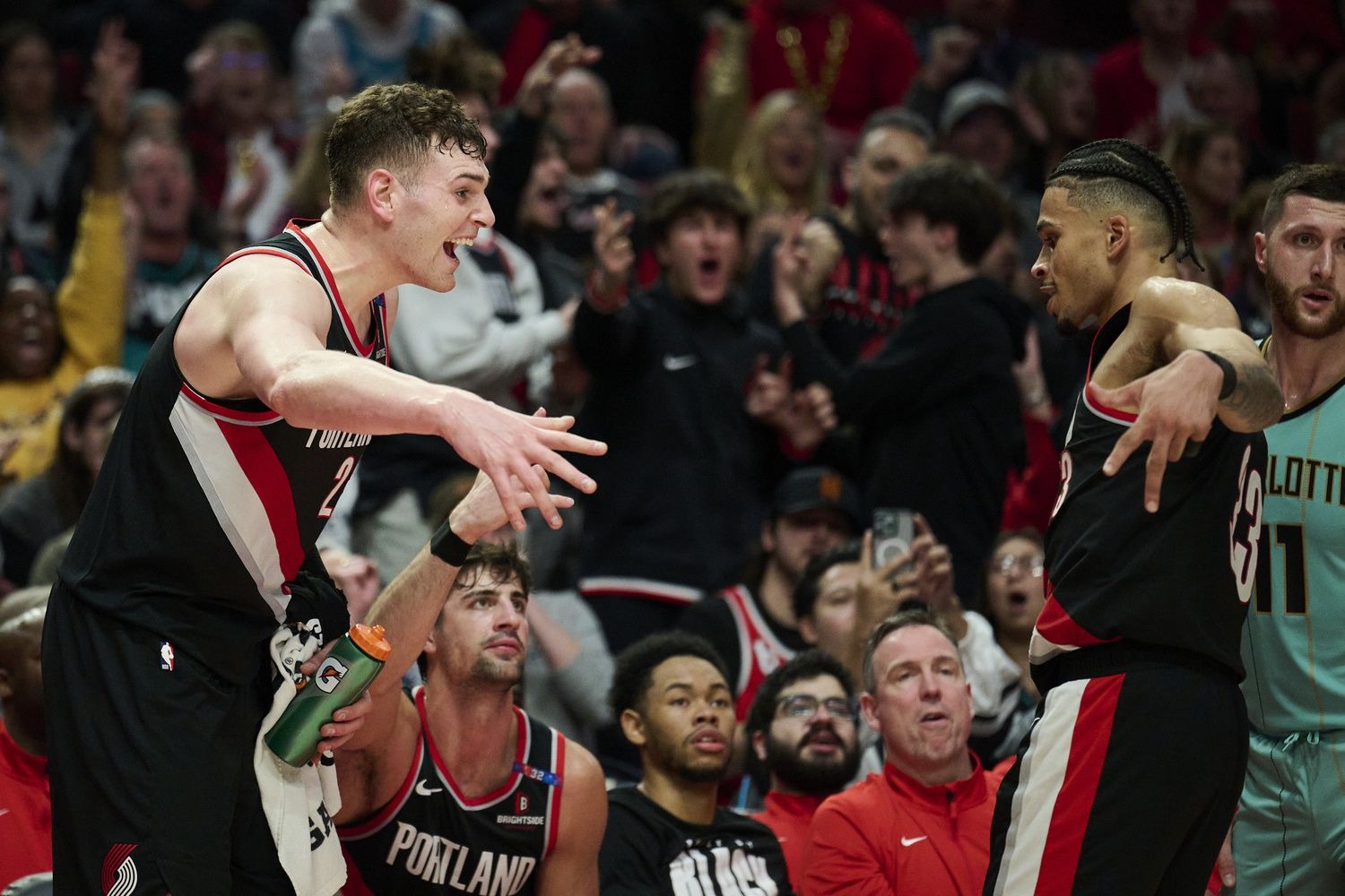 Portland Trail Blazers center Donovan Clingan (23), left, celebrates a three point basket by forward Toumani Camara (33) during the second half against the Charlotte Hornets at Moda Center.