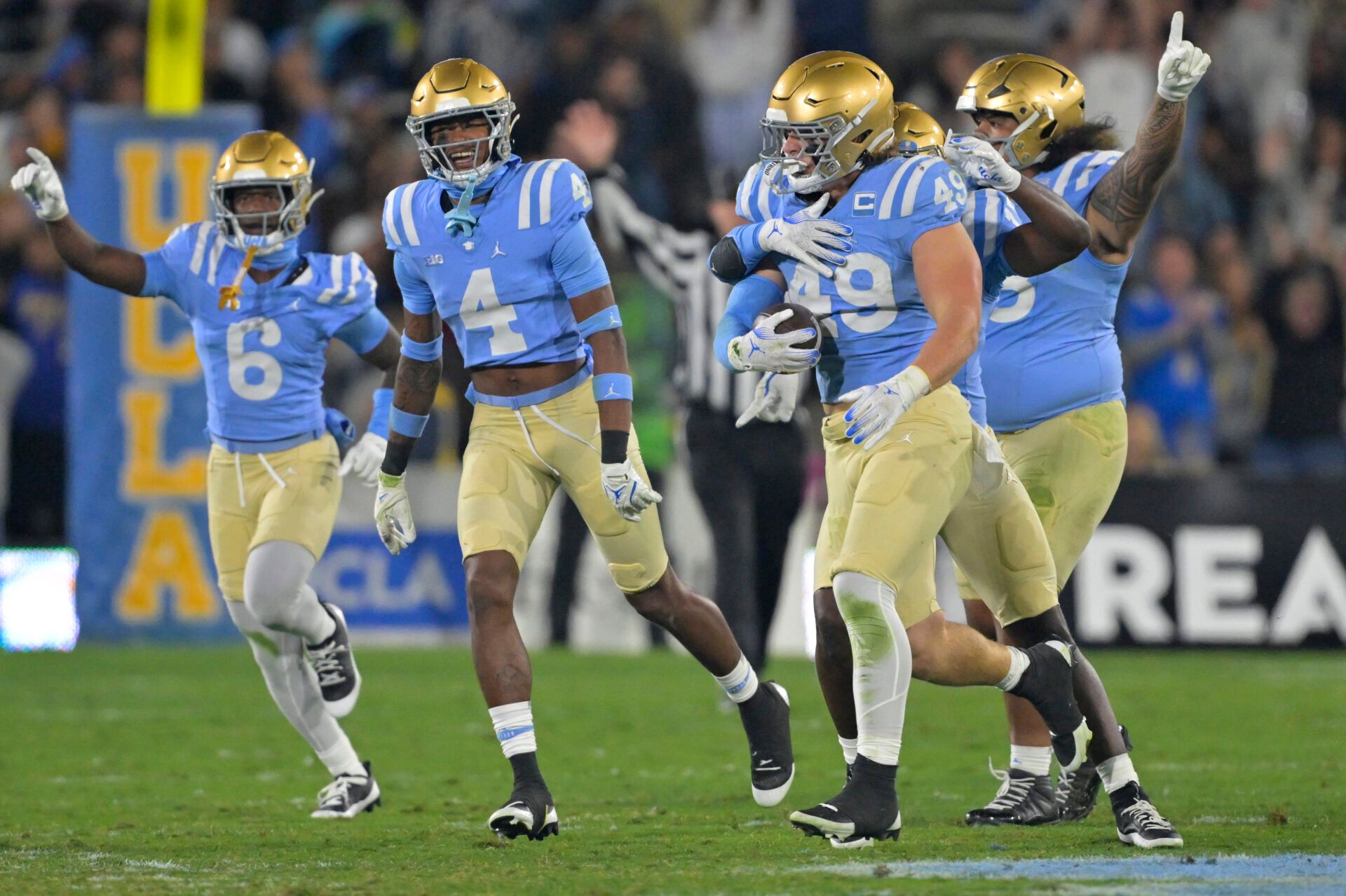 UCLA Bruins linebacker Carson Schwesinger (49) and teammates celebrate after an interception in the second half against the Iowa Hawkeyes at the Rose Bowl.