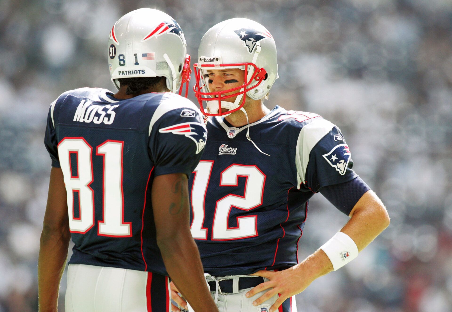 New England Patriots quarterback Tom Brady (12) talks to wide receiver Randy Moss (81) before the game against the Dallas Cowboys at Texas Stadium.