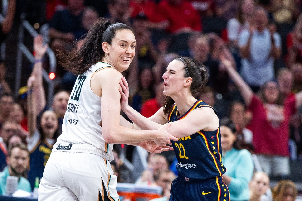 Indiana Fever guard Caitlin Clark (22) celebrates a made basket with New York Liberty forward Breanna Stewart (30)in the first half against the New York Liberty at Gainbridge Fieldhouse.