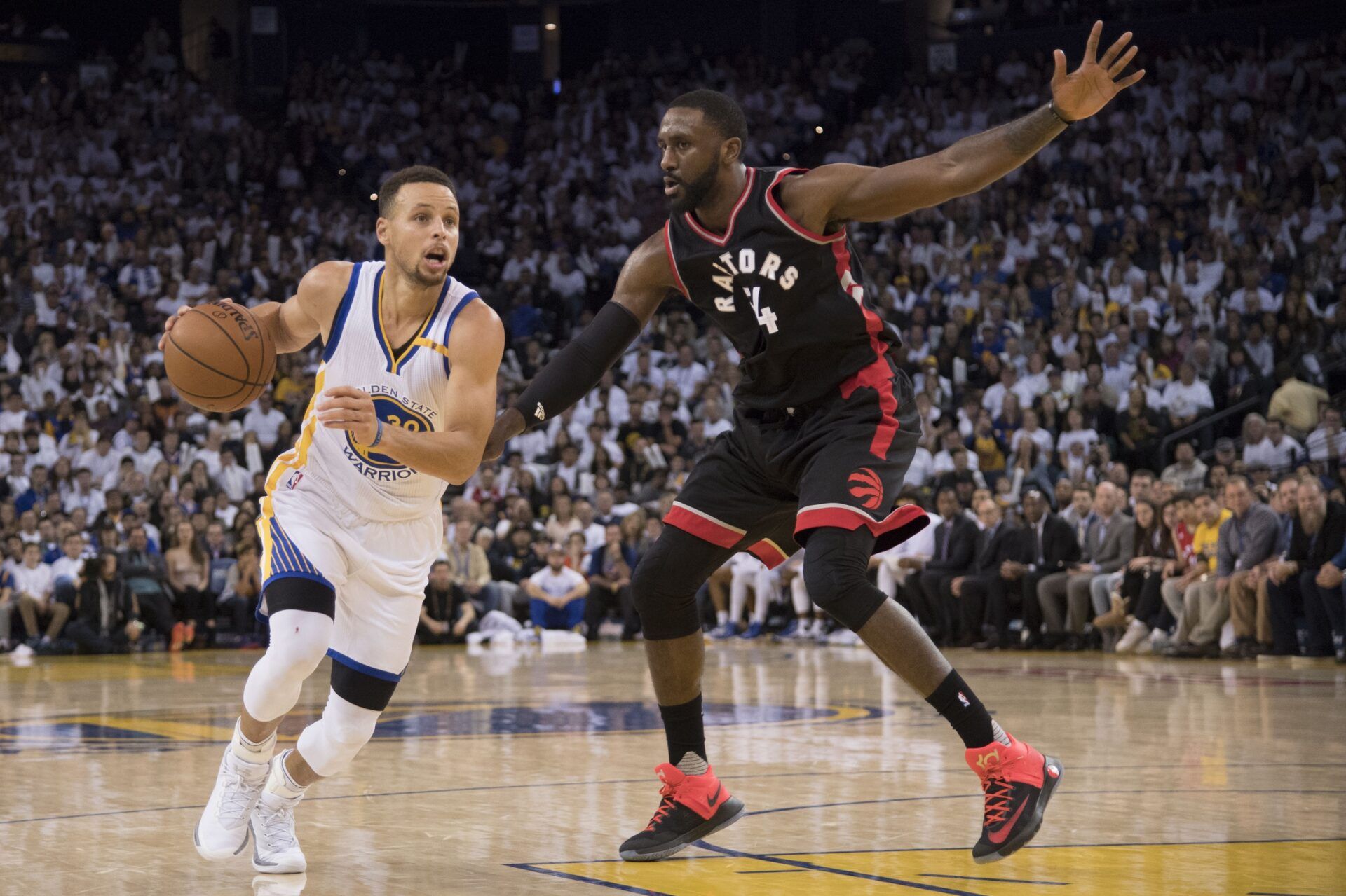 Golden State Warriors guard Stephen Curry (30) dribbles the basketball against Toronto Raptors forward Patrick Patterson (54) during the third quarter at Oracle Arena. The Warriors defeated the Raptors 121-111.