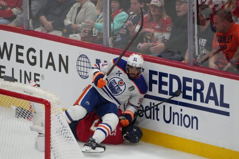 Edmonton Oilers left wing Evander Kane (91) boards Florida Panthers defenseman Seth Jones (3) during the first period in game four of the 2025 Stanley Cup Final at Amerant Bank Arena.