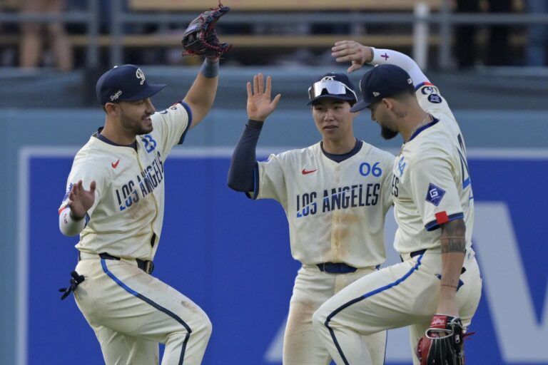 Los Angeles Dodgers left fielder Michael Conforto (23), center fielder Hyeseong Kim (6) and right fielder Andy Pages (44) celebrate after the final out of the ninth inning against the New York Yankees at Dodger Stadium.