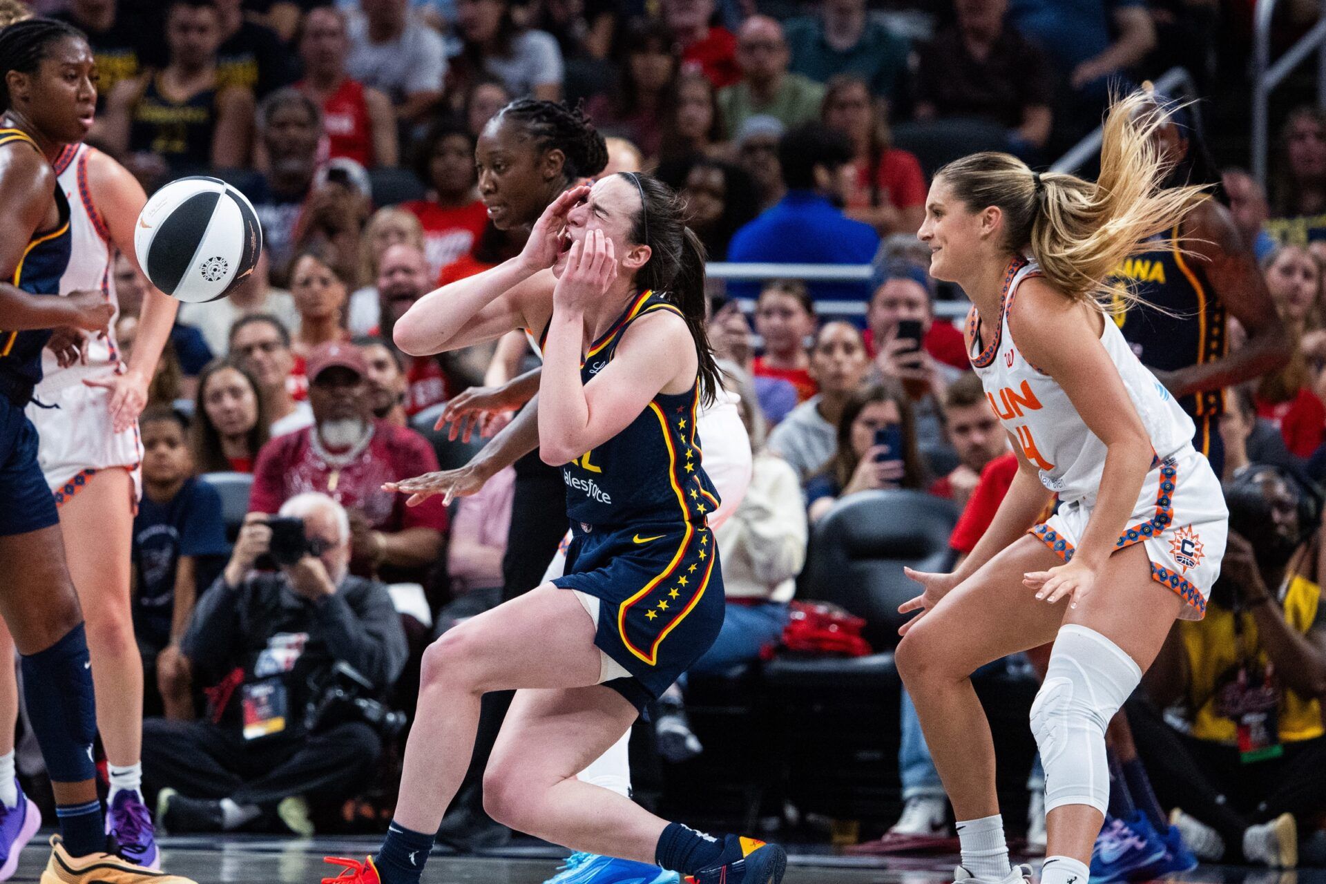 Connecticut Sun guard Jacy Sheldon (4) fouls Indiana Fever guard Caitlin Clark (22) in the second half at Gainbridge Fieldhouse.