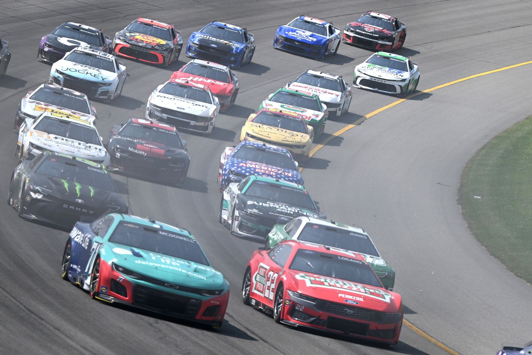The field accelerates through turn one on a restart in stage two of FireKeepers Casino 400 at Michigan International Speedway.