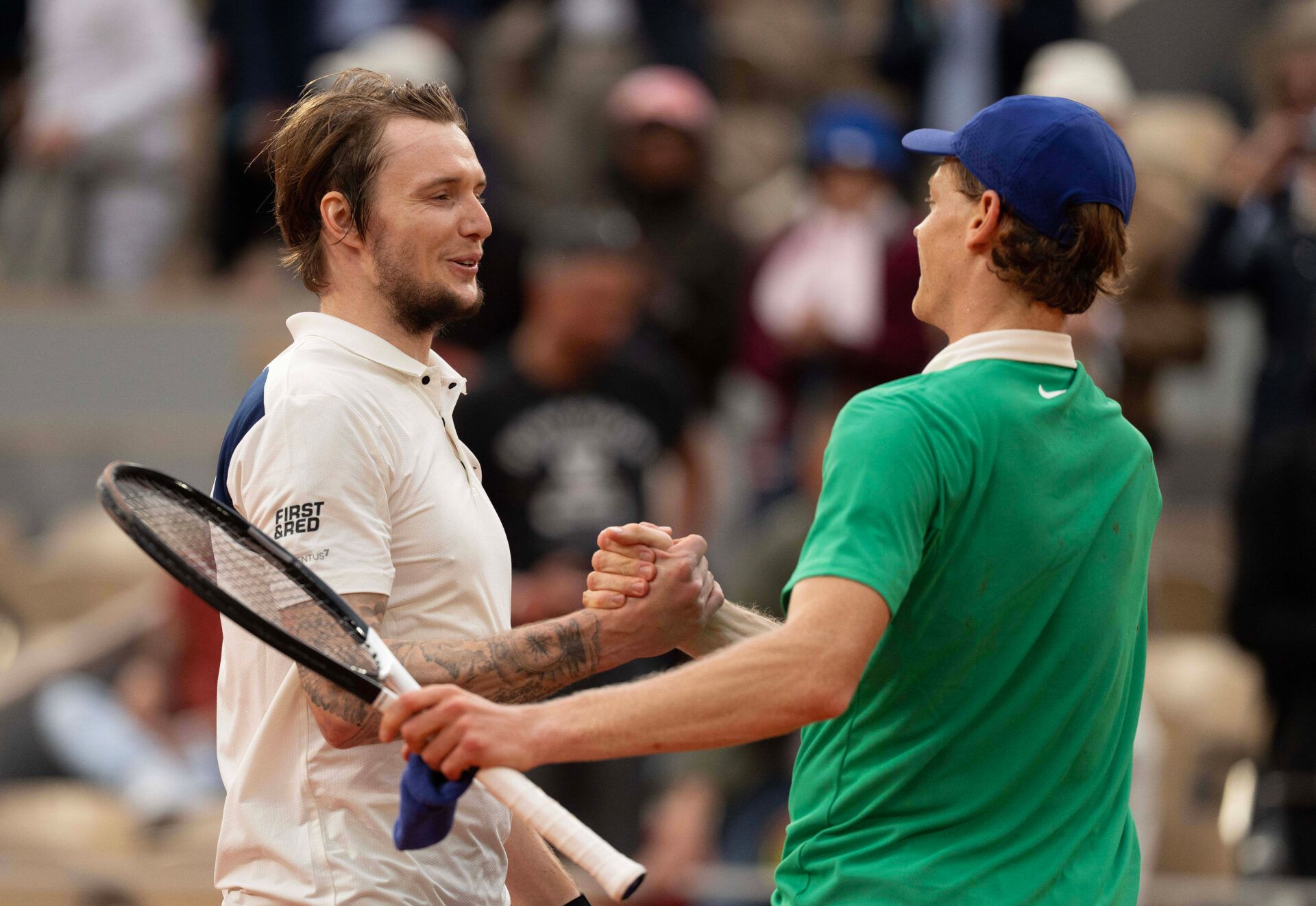 Jannik Sinner of Italy at the net with Alexander Bublik of Kazakhstan after their match on day 11 at Roland Garros Stadium.