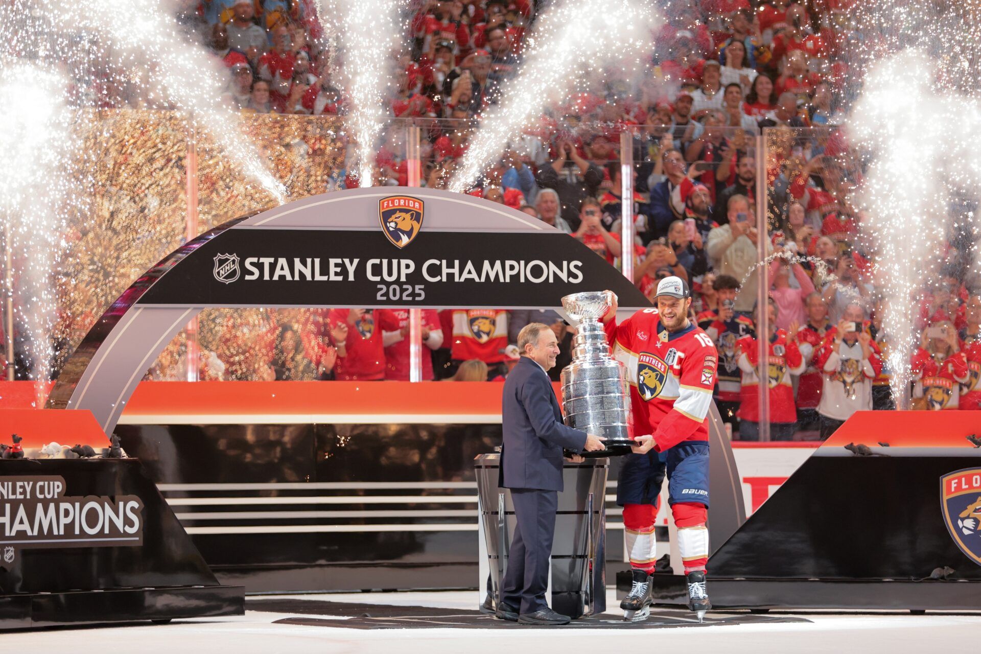Florida Panthers center Aleksander Barkov (16) is handed the Stanley Cup from Gary Bettman, the NHL Commissioner, after winning game six of the 2025 Stanley Cup Final against the Edmonton Oilers at Amerant Bank Arena.