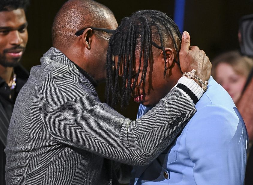 Colorado Buffaloes wide receiver/cornerback Travis Hunter with head coach Deion Sanders after winning the 2024 Heisman Trophy.