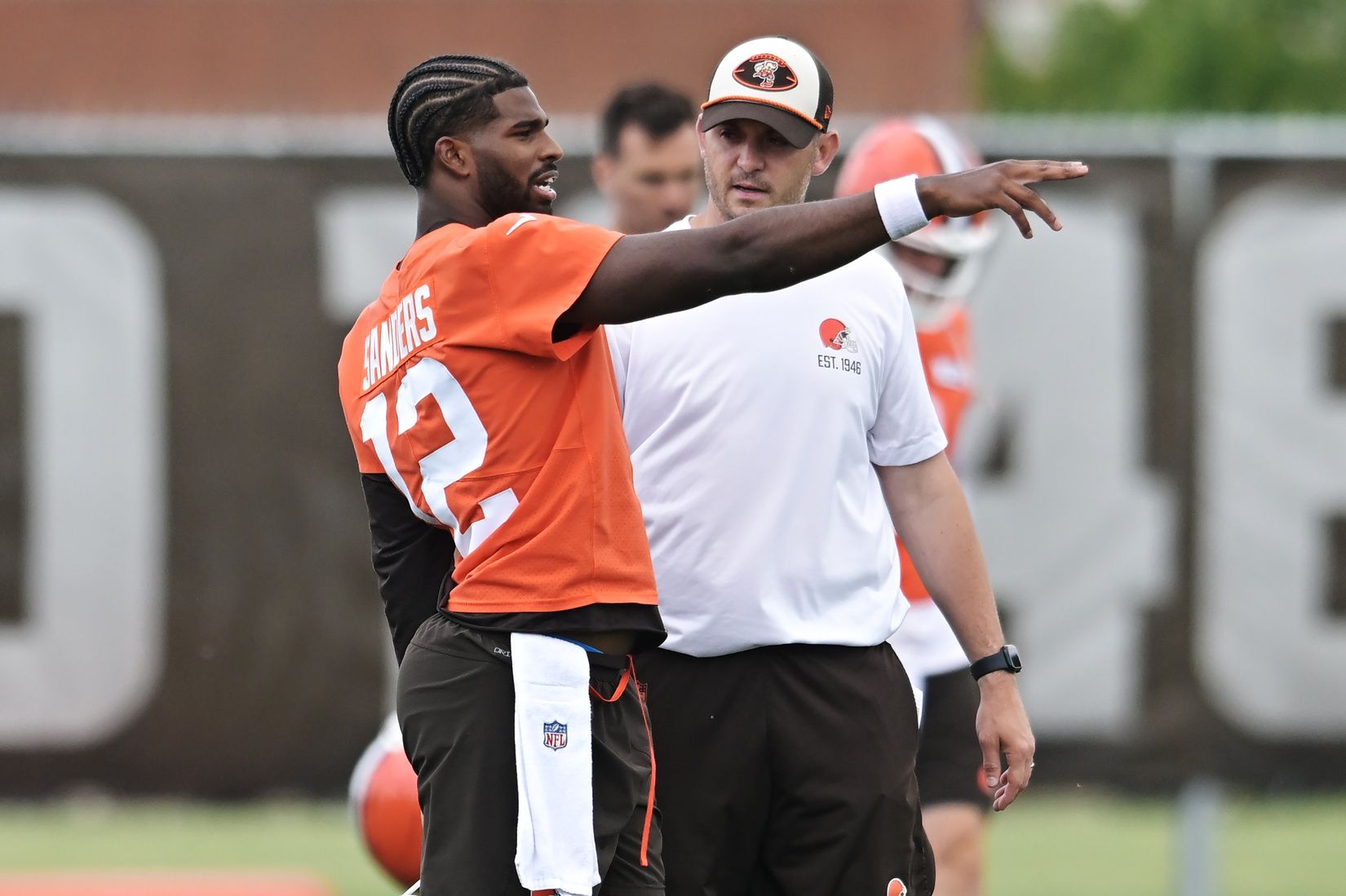 Cleveland Browns quarterback Shedeur Sanders (12) talks to Cleveland Browns offensive coordinator Tommy Rees during minicamp at CrossCountry Mortgage Campus.
