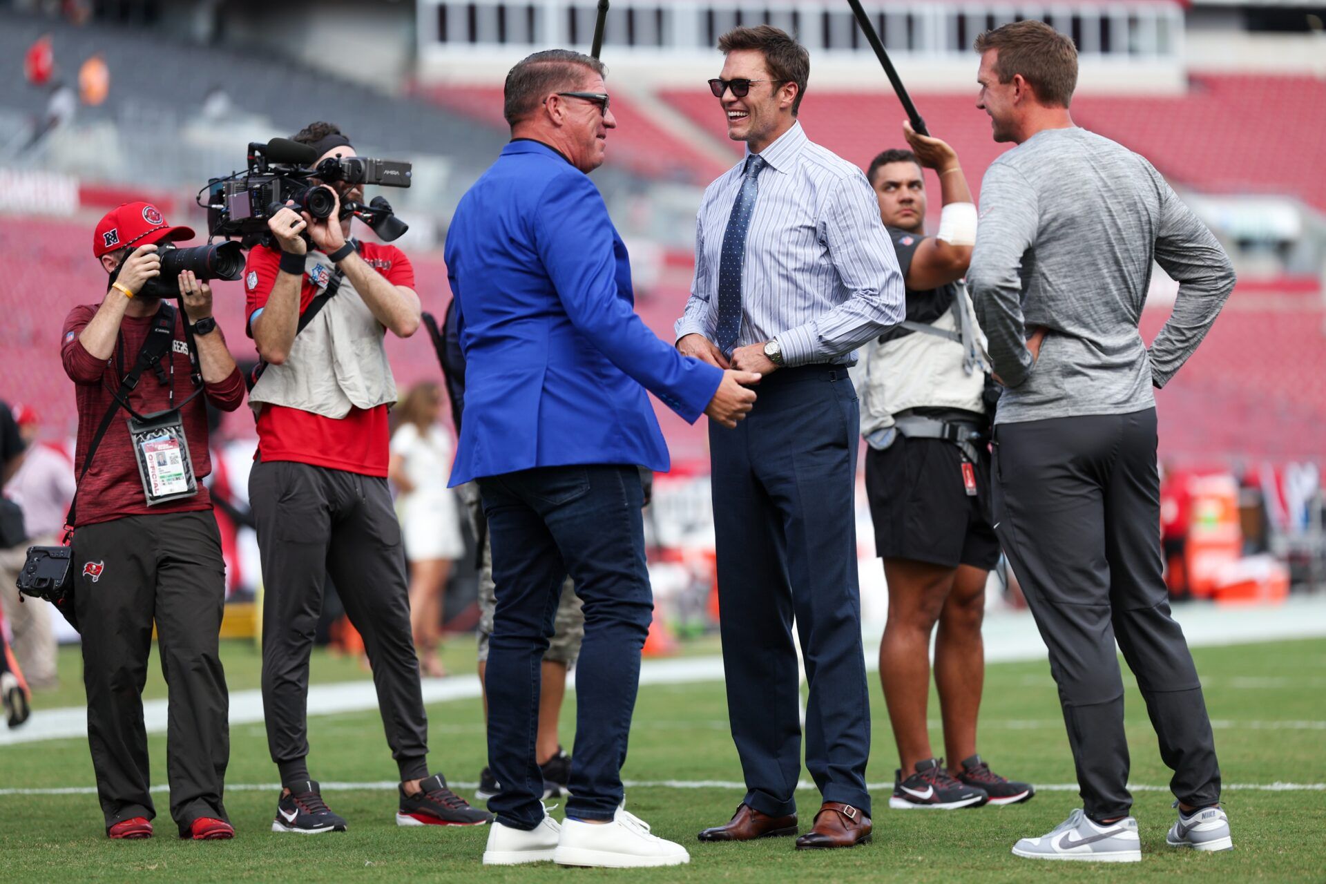 Fox NFL broadcaster and former NFL quarterback Tom Brady speaks to Tampa Bay Buccaneers general manager Jason Licht before a game against the Philadelphia Eagles at Raymond James Stadium.