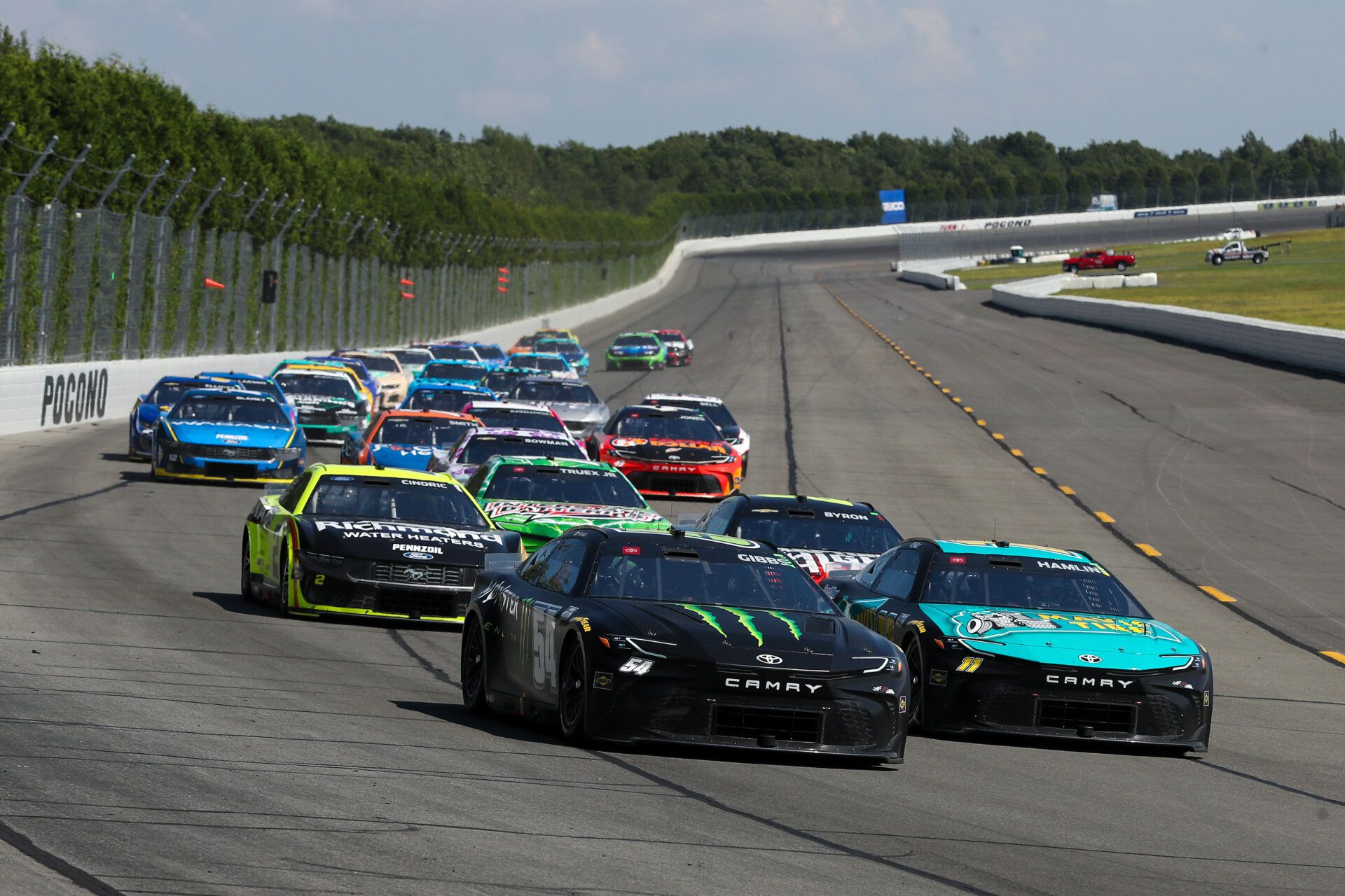 NASCAR Cup Series driver Denny Hamlin (11) races to the inside of driver Ty Gibbs (54) during The Great American Getaway 400 at Pocono Raceway.