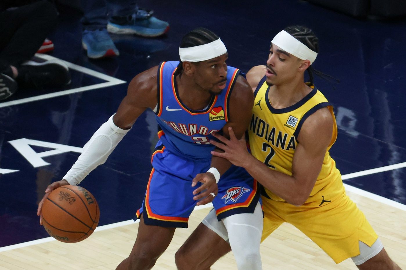 Indiana Pacers guard Andrew Nembhard (2) defends against Oklahoma City Thunder guard Shai Gilgeous-Alexander (2) in the first quarter during game six of the 2025 NBA Finals at Gainbridge Fieldhouse.