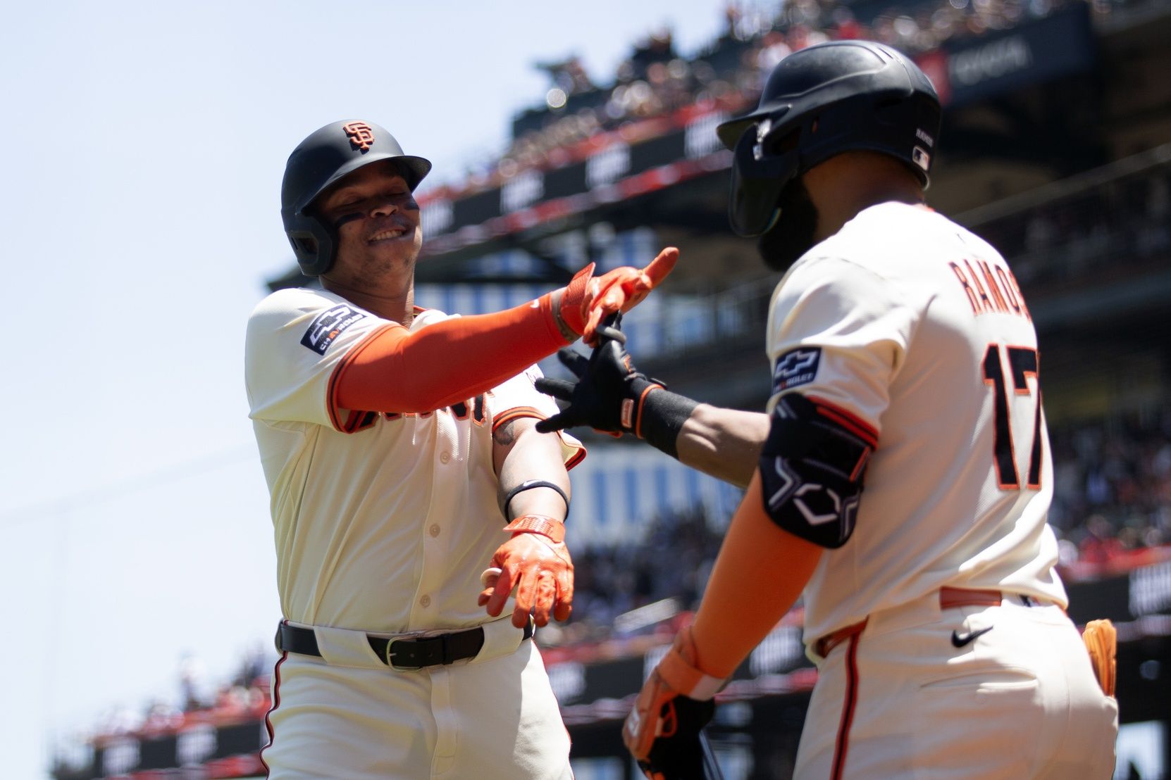 San Francisco Giants designated hitter Rafael Devers (16) gets a congratulatory handshake from teammate Heliot Ramos (17) after hitting a two-run home run against the Boston Red Sox during the third inning at Oracle Park.