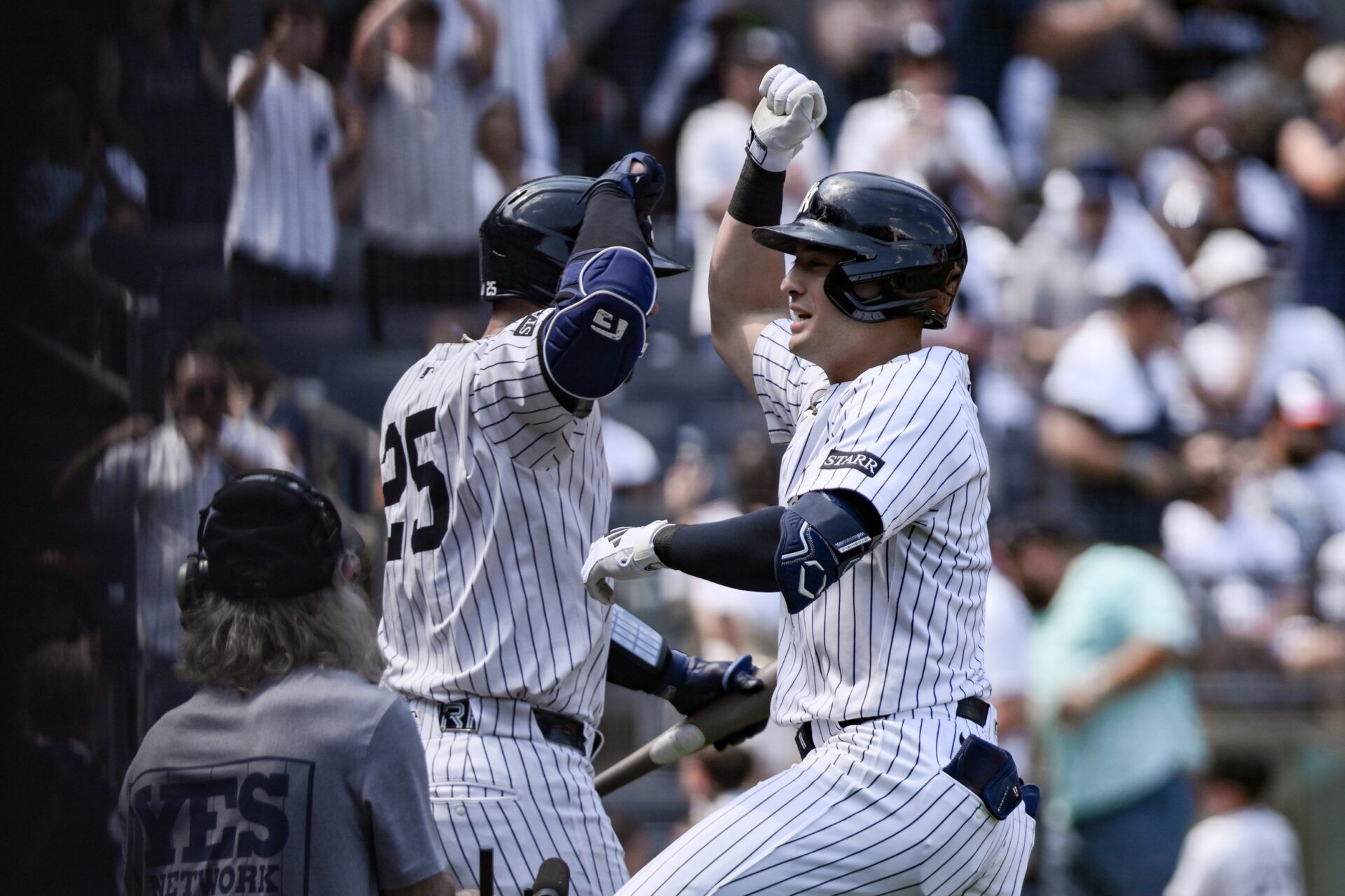 New York Yankees shortstop Anthony Volpe (11) is greeted by catcher J.C. Escarra (25) after hitting a solo home run against the Baltimore Orioles during the fifth inning at Yankee Stadium.
