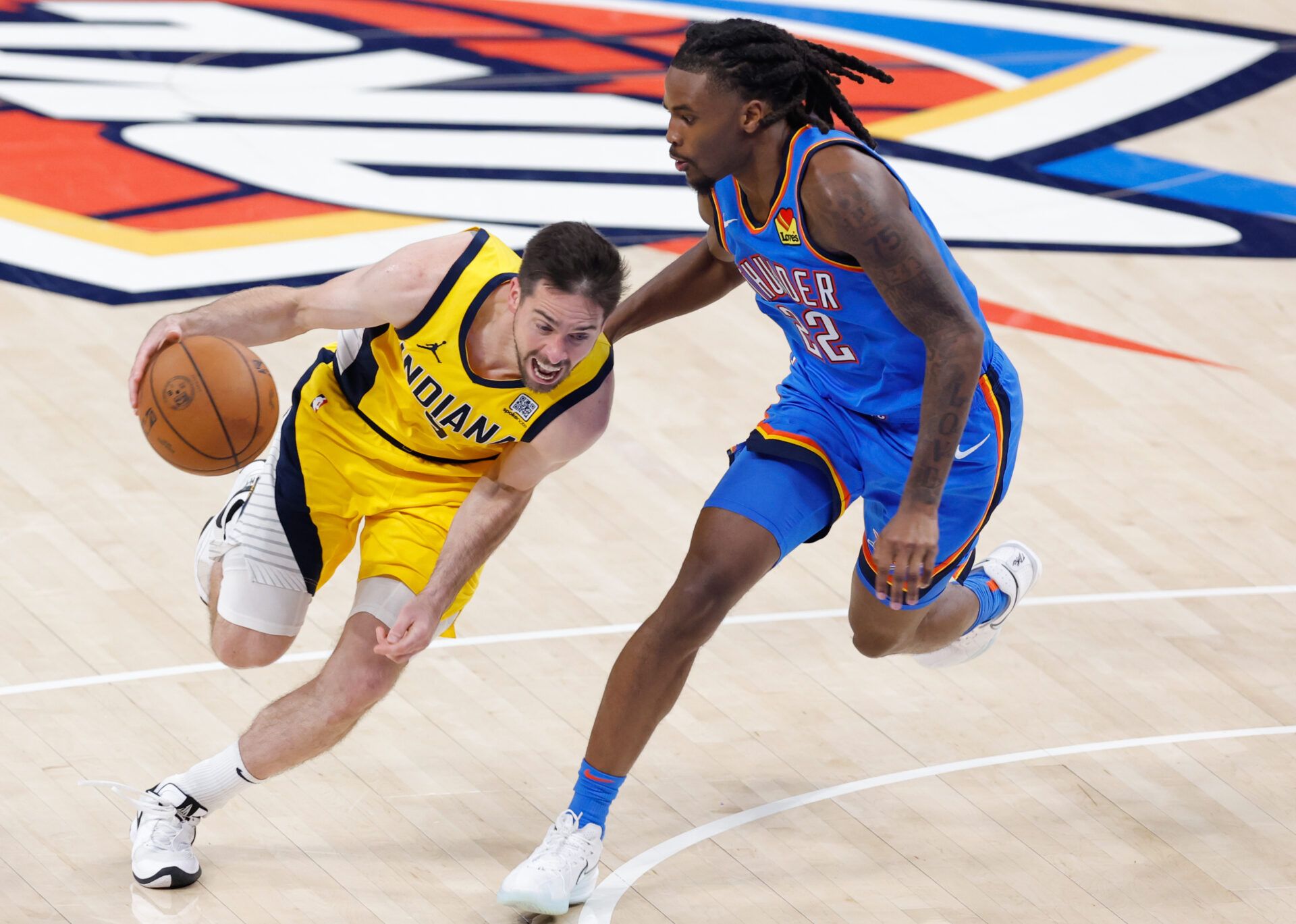 Indiana Pacers guard T.J. McConnell (9) dribbles against Oklahoma City Thunder guard Cason Wallace (22) during the second half of game seven of the 2025 NBA Finals at Paycom Center.