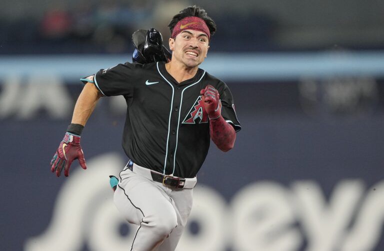 Arizona Diamondbacks right fielder Corbin Carroll (7) loses his helmet as he runs to third base on a triple against the Toronto Blue Jays during the sixth inning at Rogers Centre.