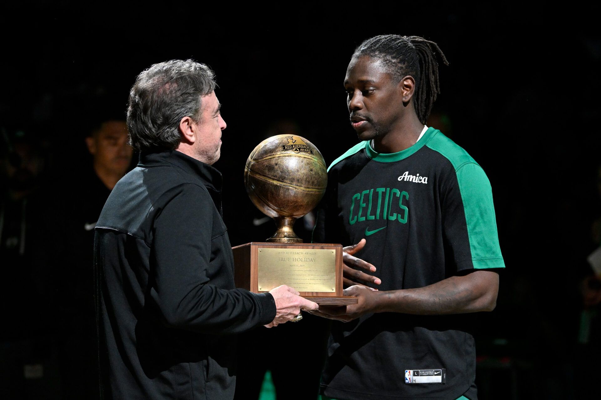 Boston Celtics owner Wycliffe K. Grousbeck presents the Red Auerbach award to guard Jrue Holiday (4) before a game against the Charlotte Hornets at TD Garden.