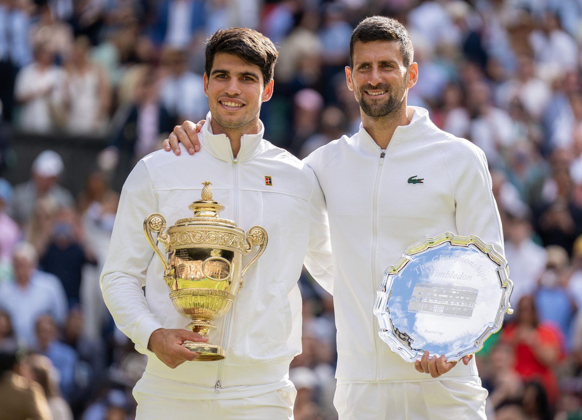 Carlos Alcaraz of Spain and Novak Djokovic of Serbia pose with their trophies after the menÕs singles final on day 14 at All England Lawn Tennis and Croquet Club.