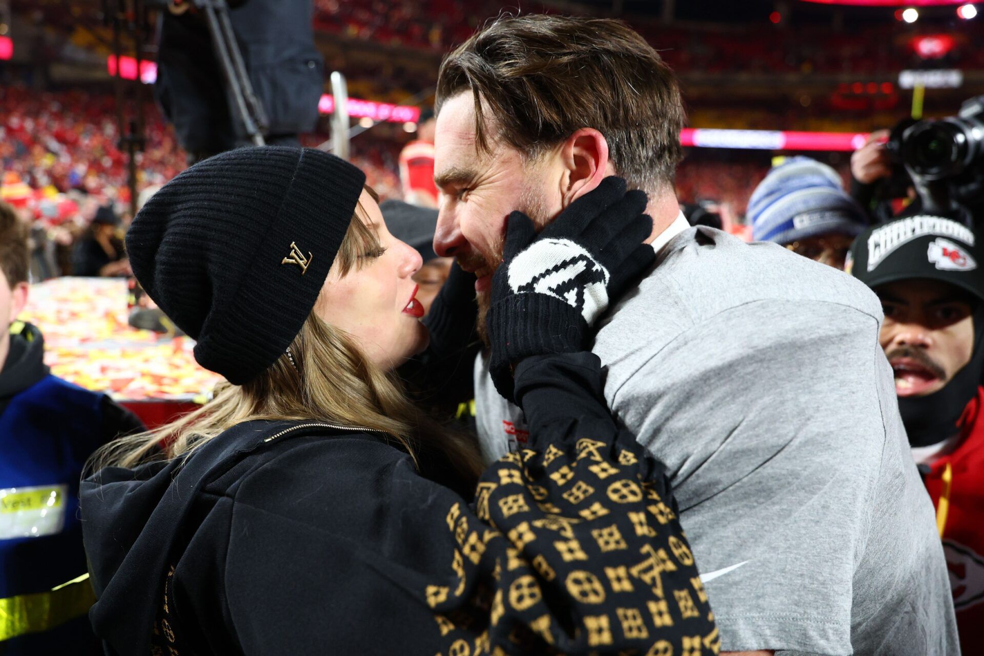 Recording artist Taylor Swift  and Kansas City Chiefs tight end Travis Kelce (87) react after the AFC Championship game against the Buffalo Bills at GEHA Field at Arrowhead Stadium.
