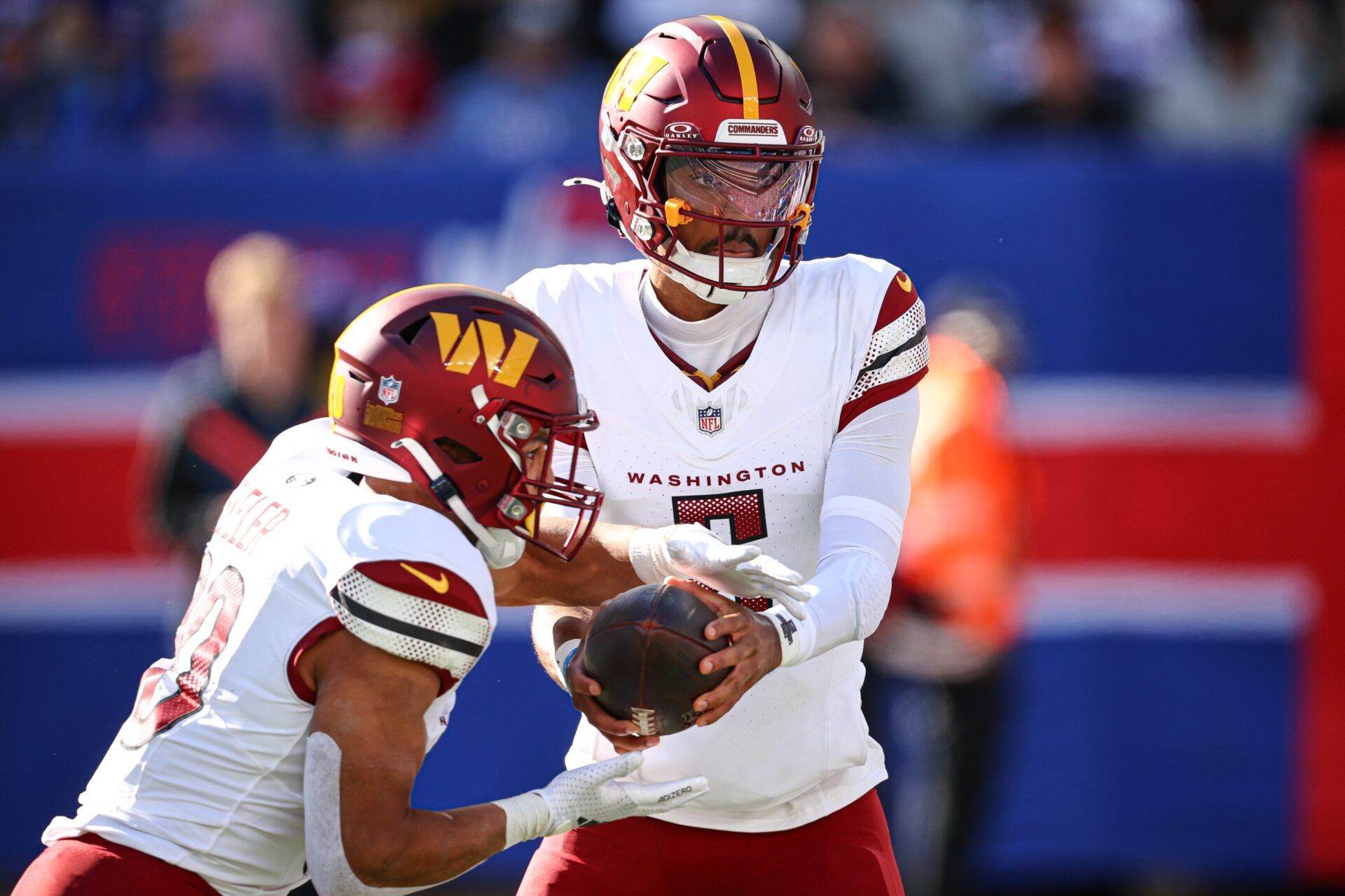 Washington Commanders quarterback Jayden Daniels (5) hands off to running back Austin Ekeler (30) during the first half against the New York Giants at MetLife Stadium.