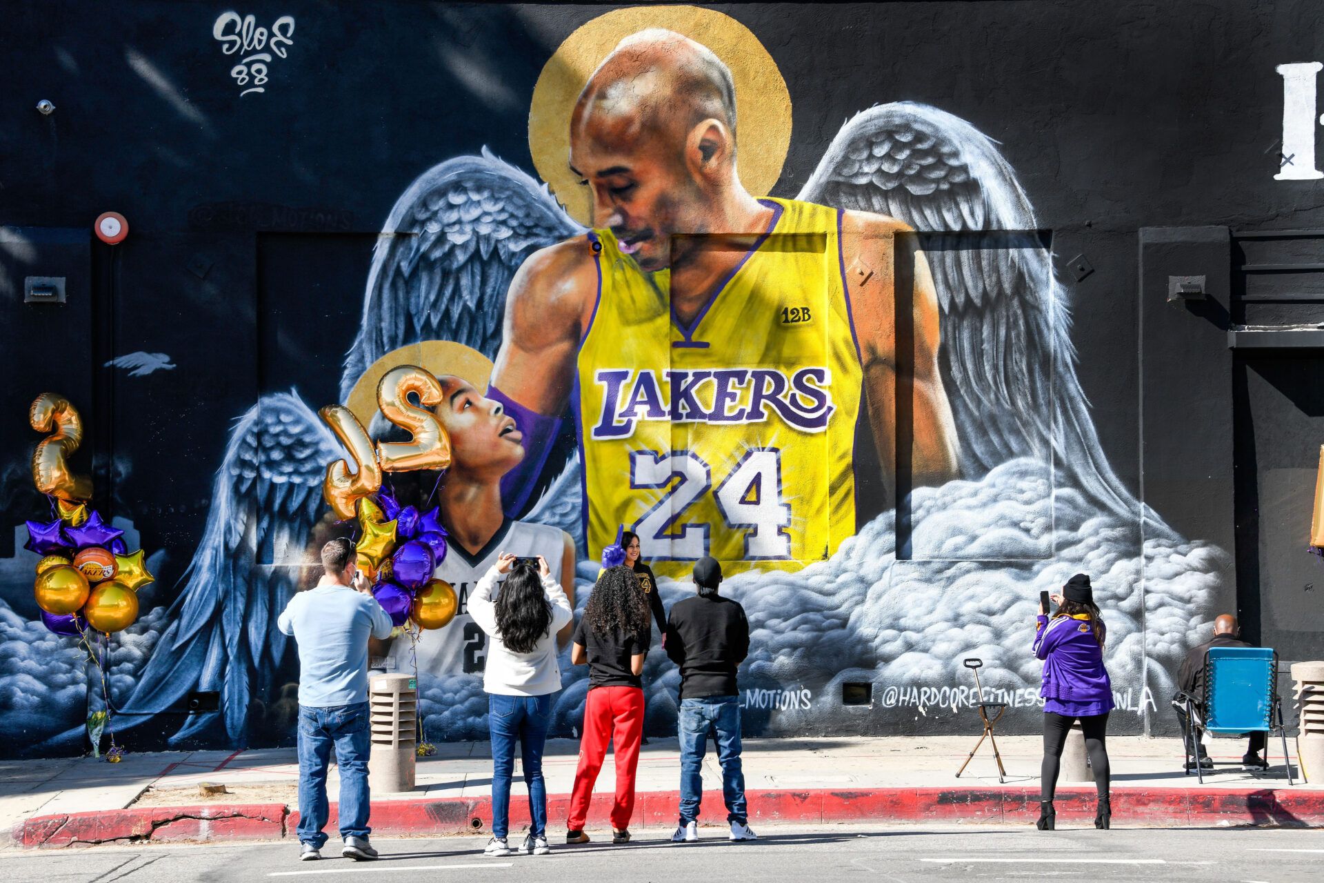 Fans gather at a mural of Kobe Bryant and his daughter Gianna painted on the wall of Hardcore Fitness Bootcamp gym in downtown Los Angeles. Bryant and his daughter and seven other persons died in a helicopter crash in Calabasas, Calif. on Jan. 26, 2020.