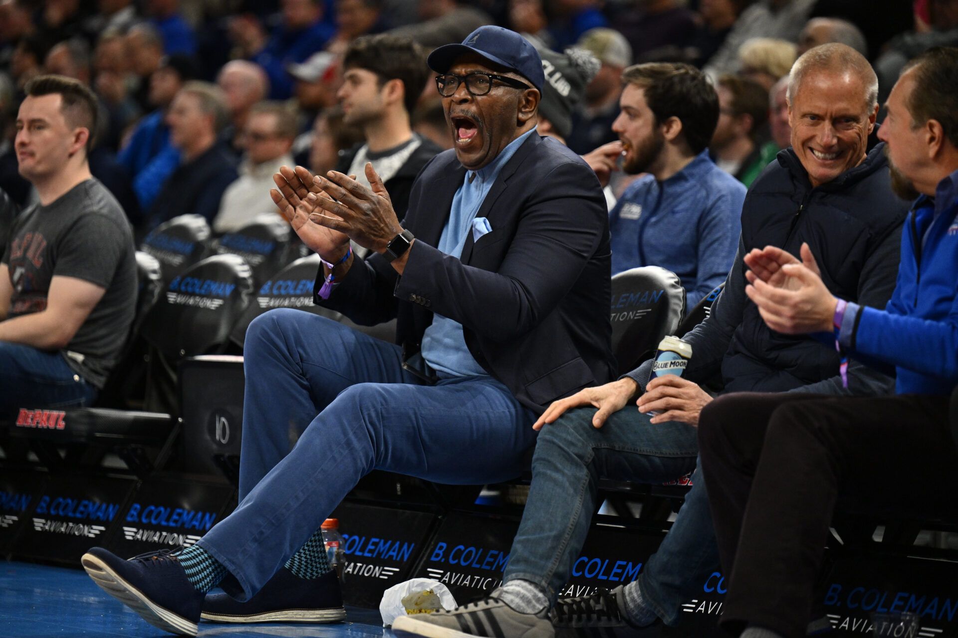 Former DePaul Blue Demons basketball player Mark Aguirre cheers while watching the Blue Demons take on the Xavier Musketeers in the first half at Wintrust Arena.