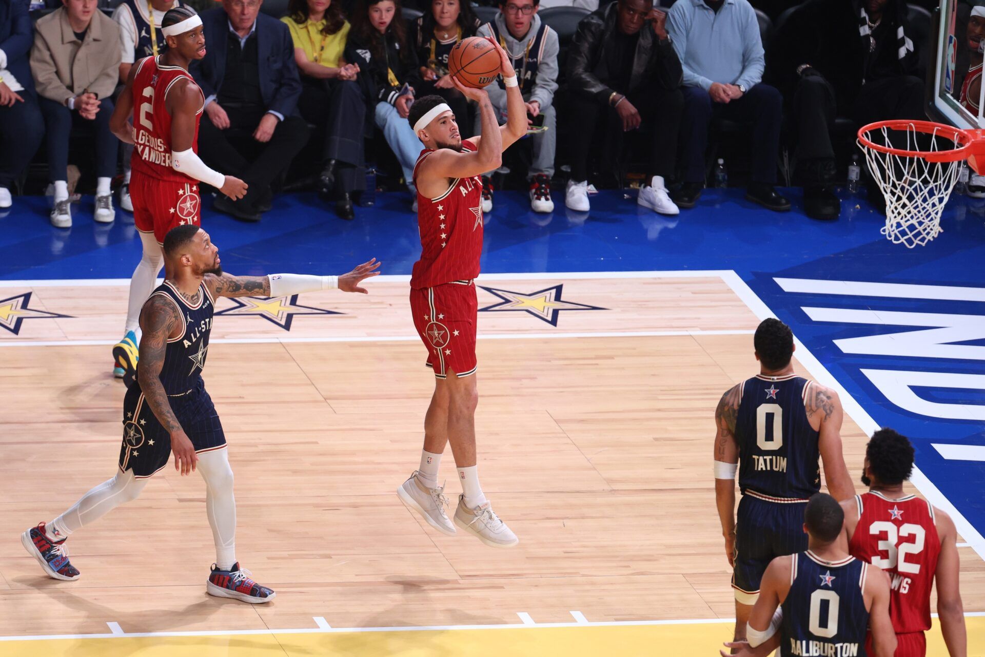 Western Conference guard Devin Booker (1) of the Phoenix Suns shoots the ball against Eastern Conference guard Damian Lillard (0) of the Milwaukee Bucks during the third quarter in the 73rd NBA All Star game at Gainbridge Fieldhouse.