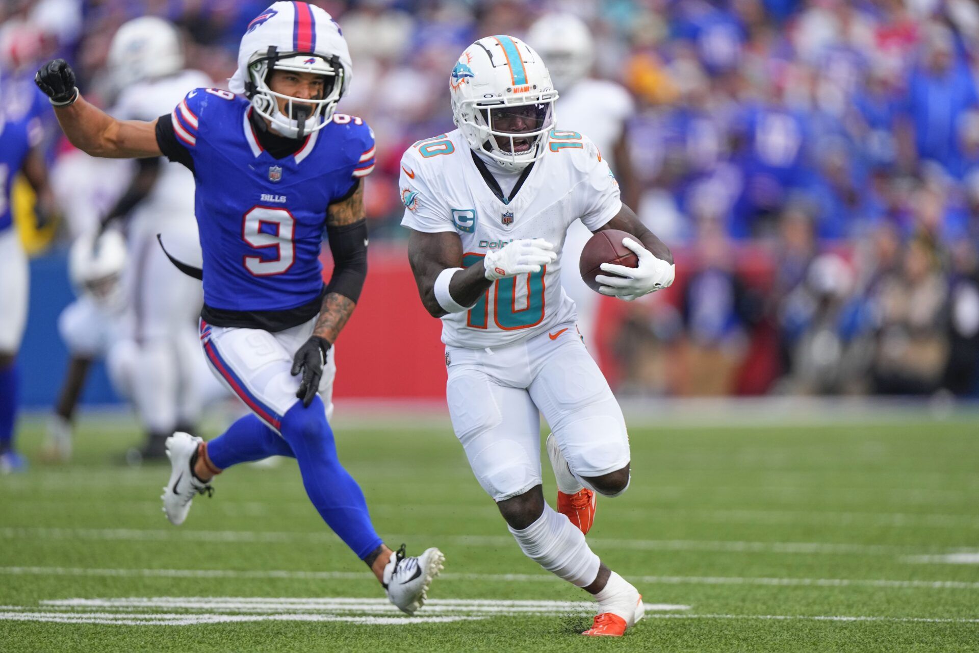 Miami Dolphins wide receiver Tyreek Hill (10) runs with the ball against Buffalo Bills safety Taylor Rapp (9) during the second half at Highmark Stadium.