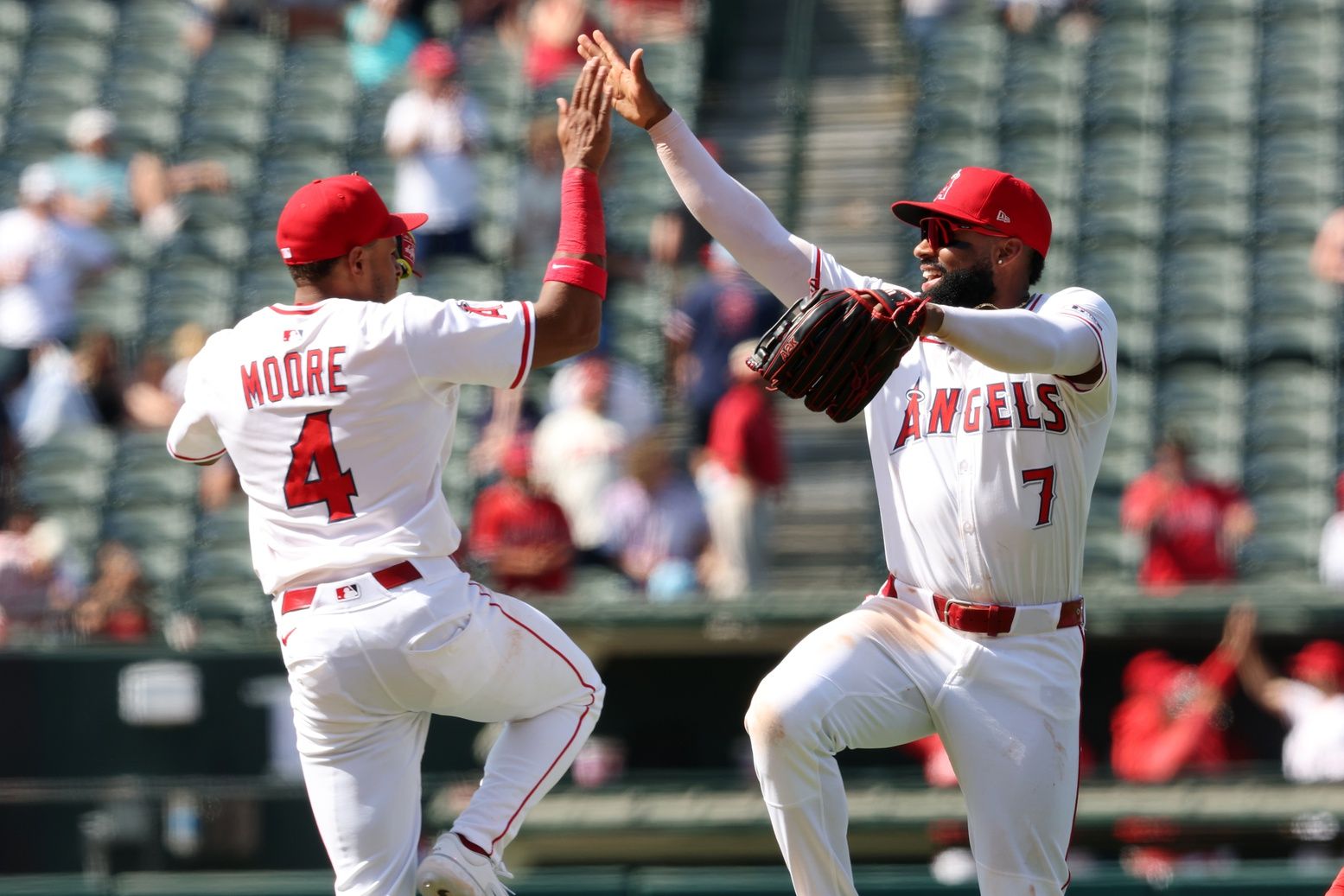 Los Angeles Angels second baseman Christian Moore (4, left) and center fielder Jo Adell (7, right) celebrate a victory after defeating the Boston Red Sox 5-2 at Angel Stadium.