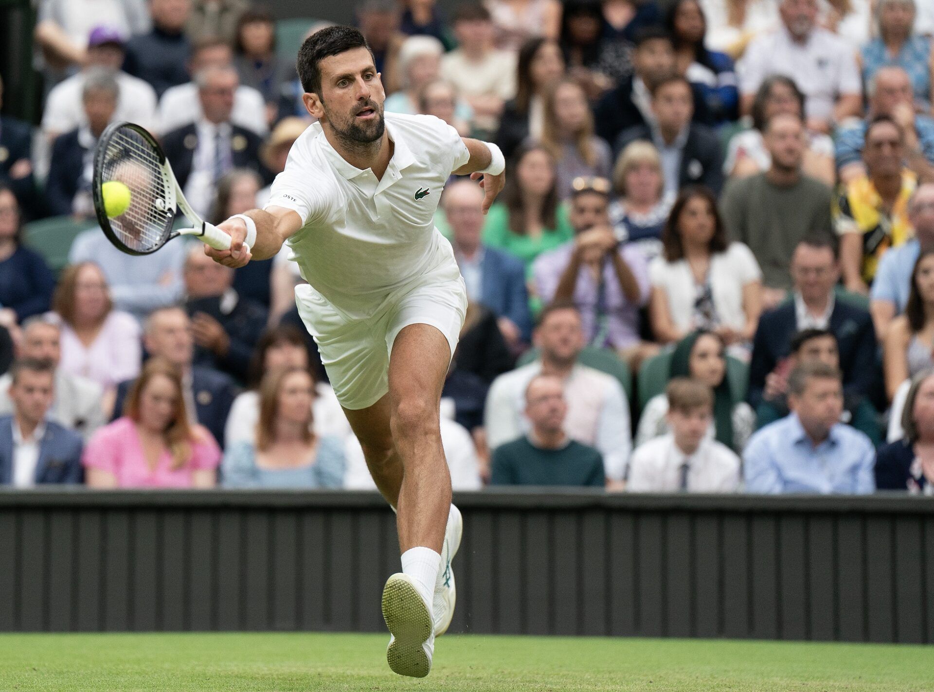 Novak Djokovic (SRB) returns a shot during his match against Jannik Sinner (ITA) on day 12 at the All England Lawn Tennis and Croquet Club.