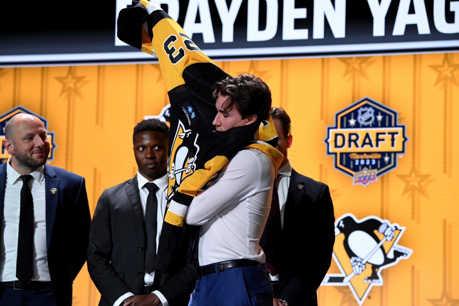 Pittsburgh Penguins draft pick Brayden Yager puts on his sweater after being selected with the fourteenth pick in round one of the 2023 NHL Draft at Bridgestone Arena.