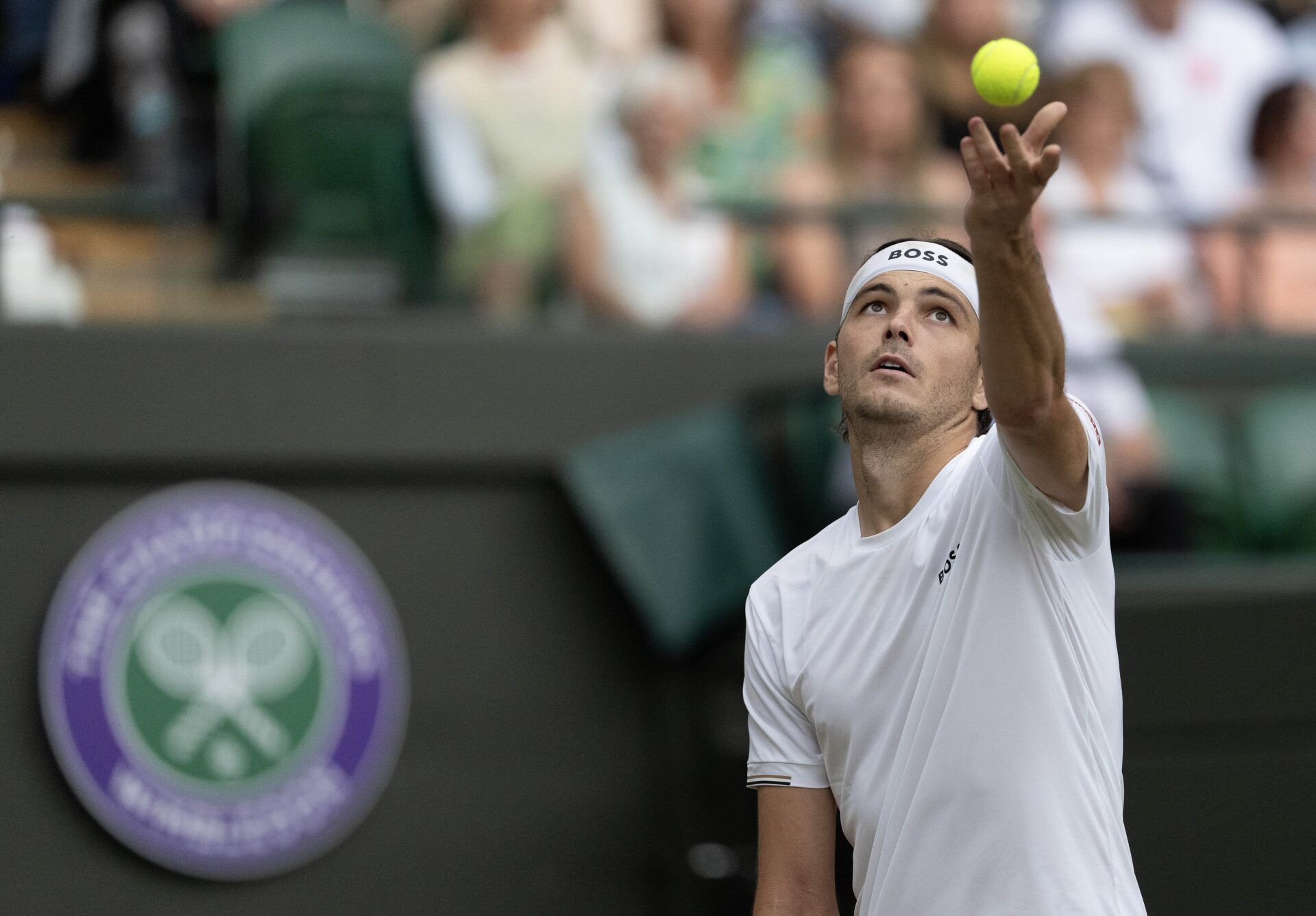 Taylor Fritz of the United States tosses the ball to serve during his match against Lorenzo Musetti of Italy (not shown) on day 10 at All England Lawn Tennis and Croquet Club.