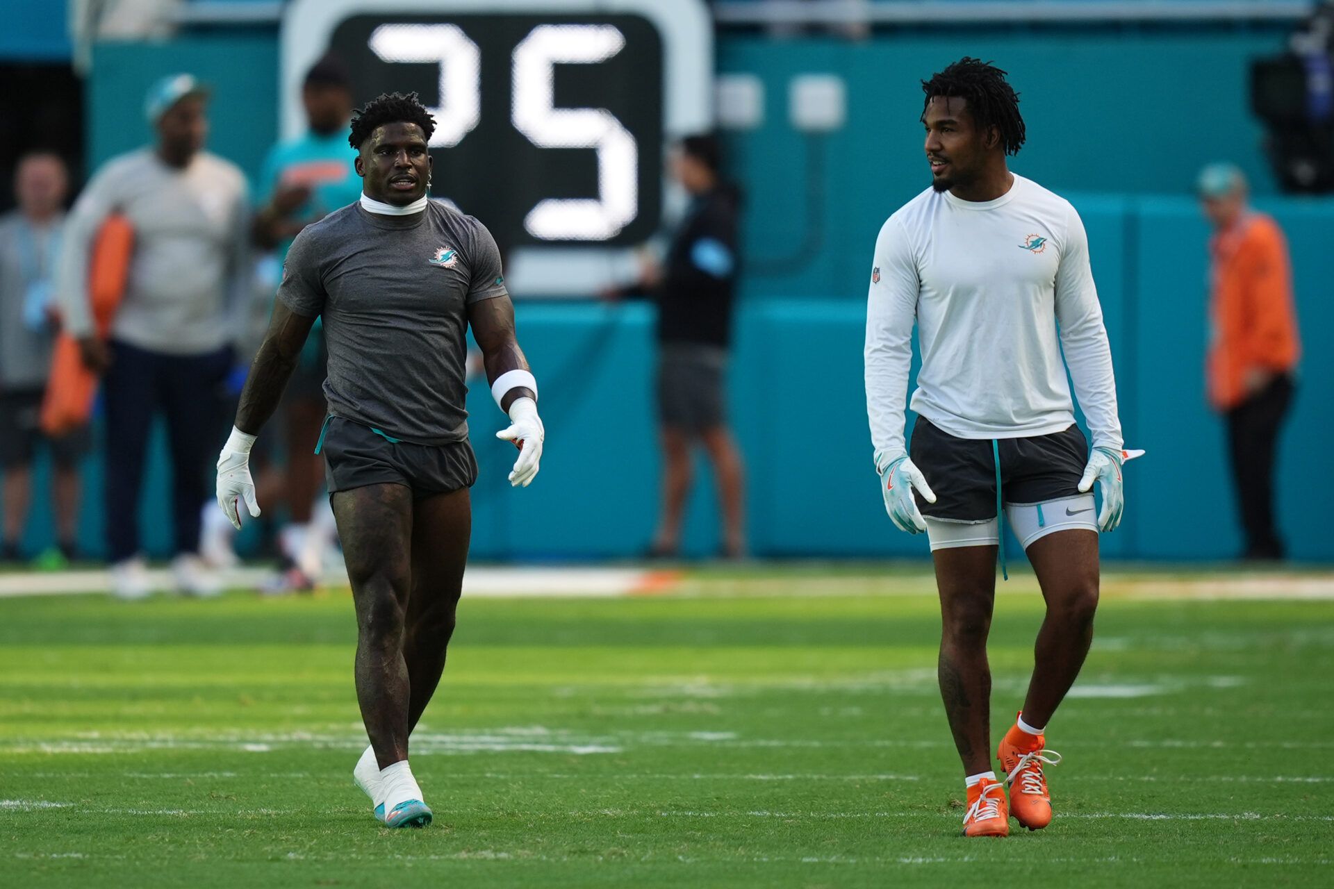 Miami Dolphins wide receiver Tyreek Hill (L) and Miami Dolphins wide receiver Jaylen Waddle (R) walk on the field prior to  the game against the New England Patriots at Hard Rock Stadium.