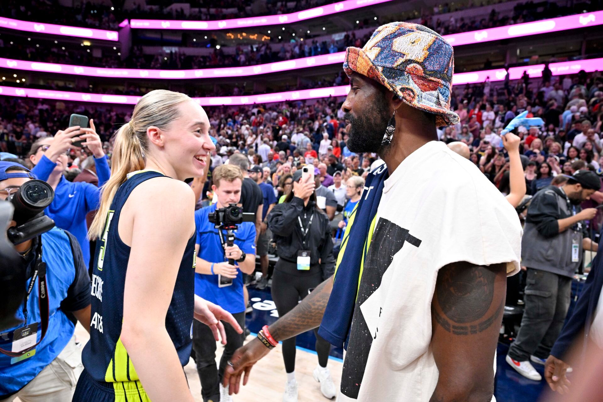 Dallas Mavericks point guard Kyrie Irving talks with Dallas Wings guard Paige Bueckers (5) after the game against the Indiana Fever at the American Airlines Center.