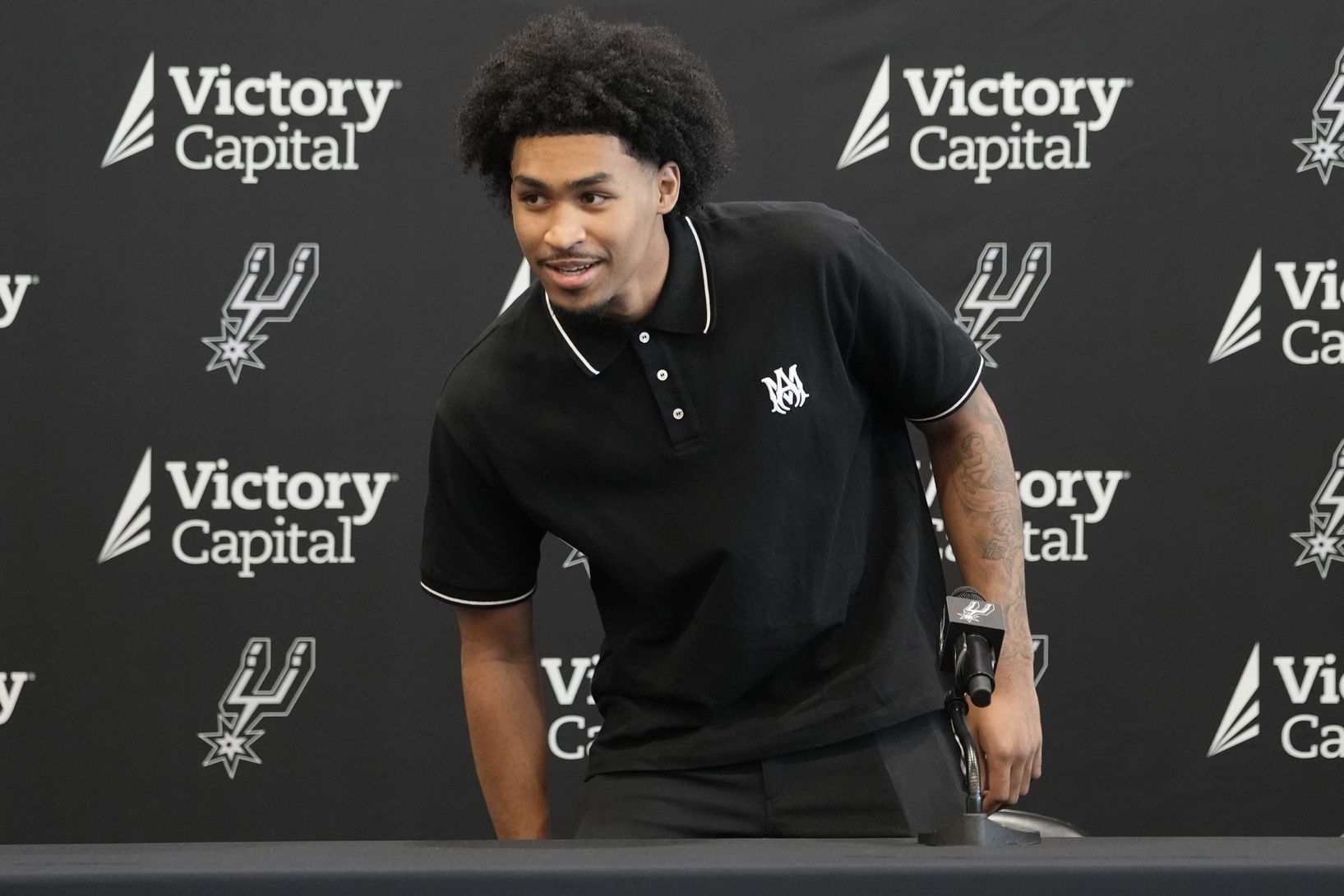 San Antonio first round draft pick Dylan Harper (2) takes a seat before a press conference at Victory Capital Performance Center.