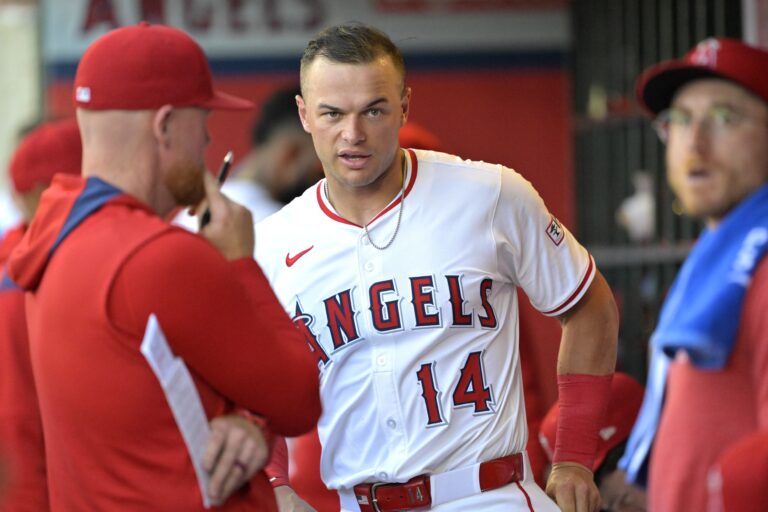 Los Angeles Angels catcher Logan O'Hoppe (14) talks with pitching coach Barry Enright (84) in the dugout during the third inning against the Washington Nationals at Angel Stadium.