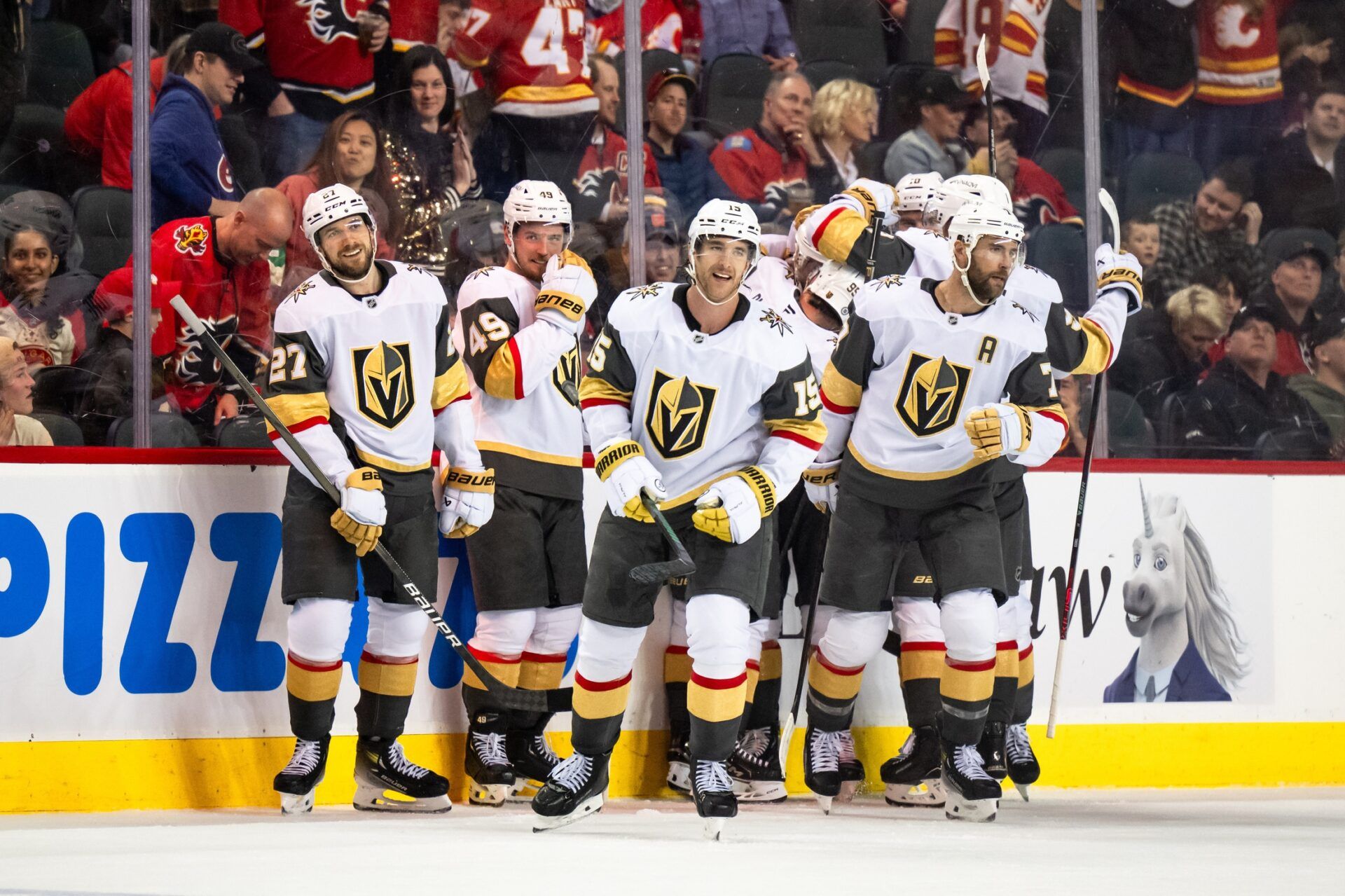 Vegas Golden Knights defenseman Shea Theodore (27), center Ivan Barbashev (49), defenseman Noah Hanifin (15), defenseman Alex Pietrangelo (7) and teammates celebrate their 3-2 overtime win over the Calgary Flames at Scotiabank Saddledome.