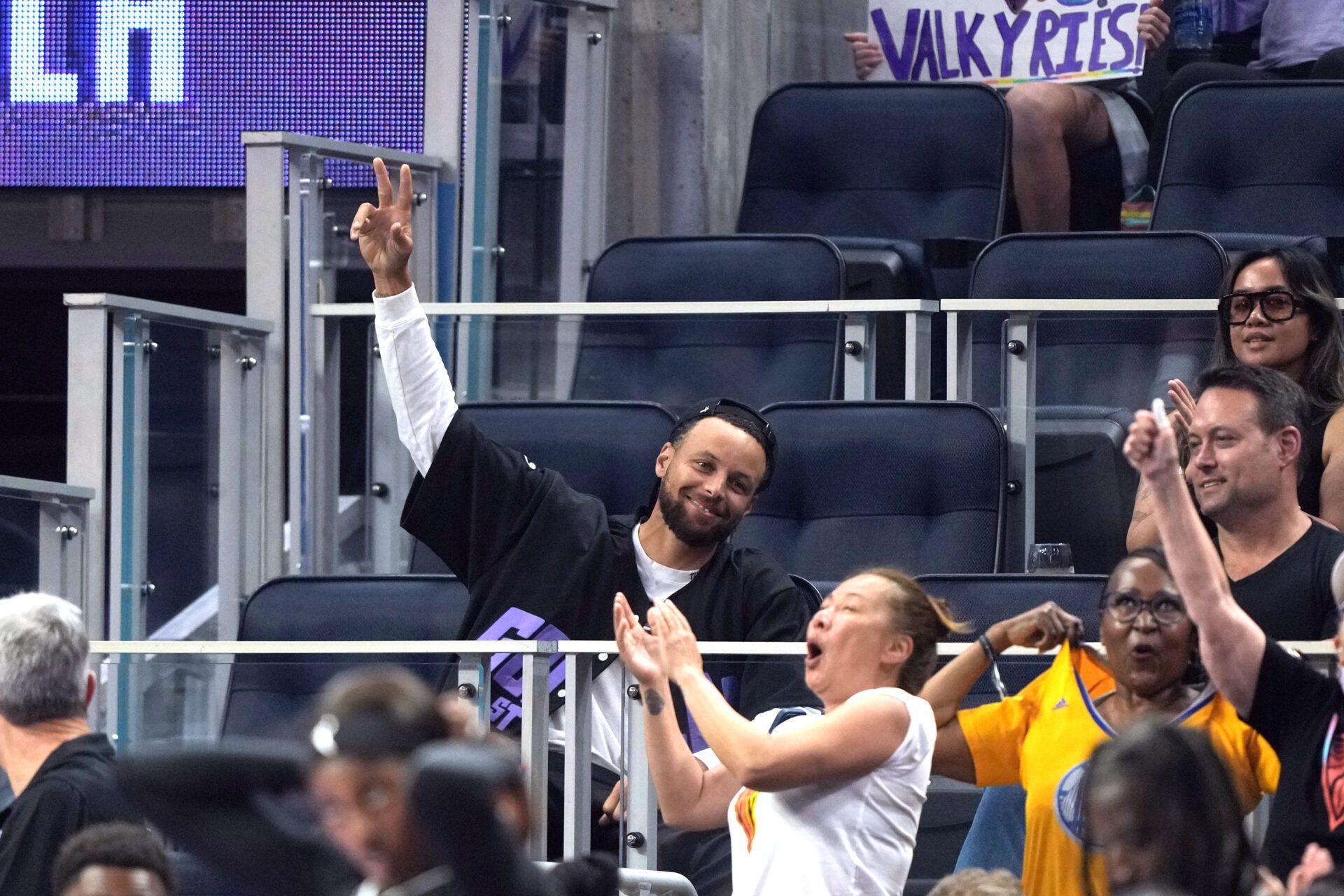 Golden State Warriors guard Stephen Curry (center) waves during the second quarter of the game between the Golden State Valkyries and the Seattle Storm at Chase Center.