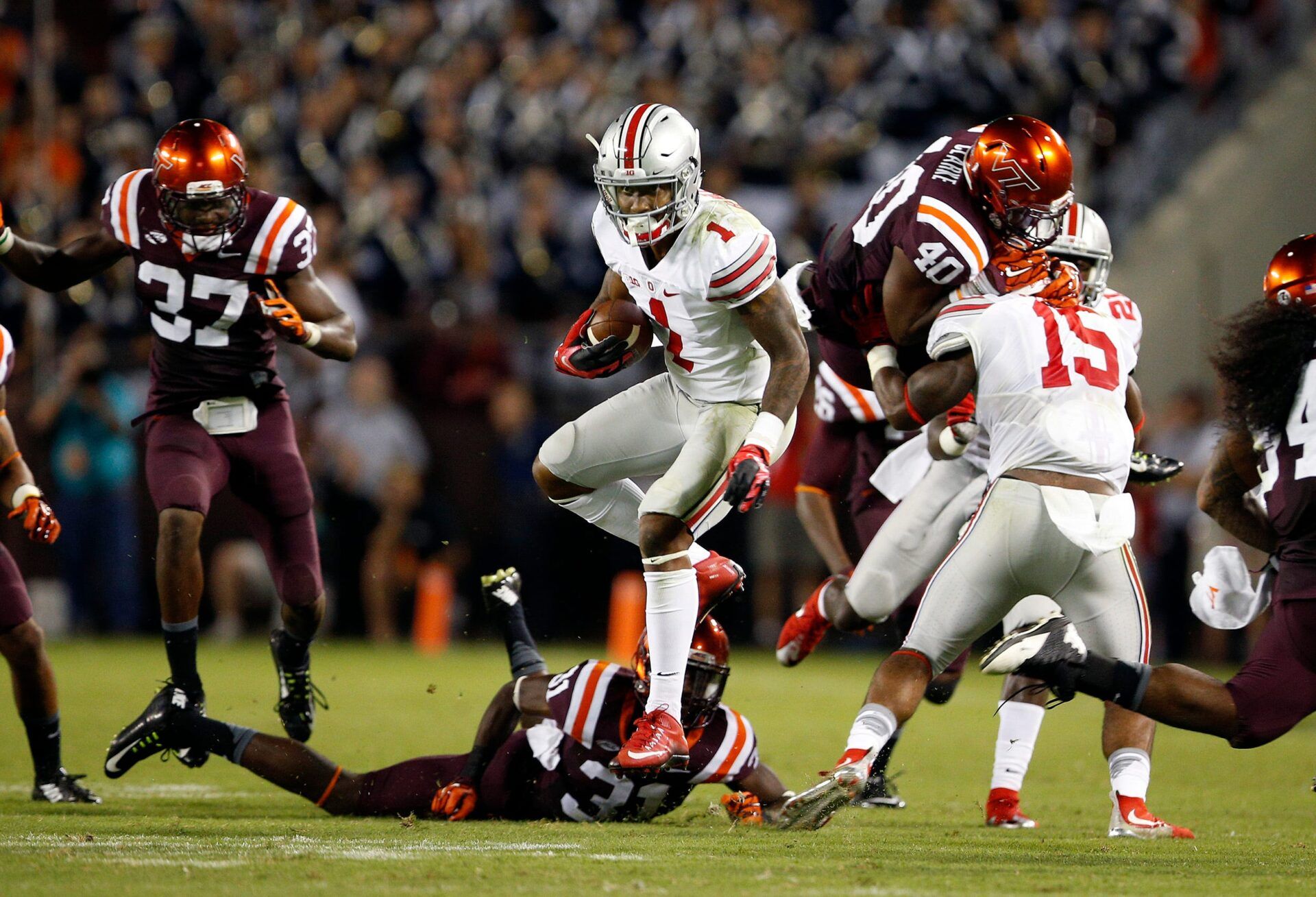Ohio State Buckeyes wide receiver Braxton Miller (1) jump spins past Virginia Tech Hokies cornerback Brandon Facyson (31) and others for a touchdown run in the 3rd quarter at Lane Stadium in Blacksburg, Va on September 7, 2015. (Dispatch photo by Kyle Robertson)