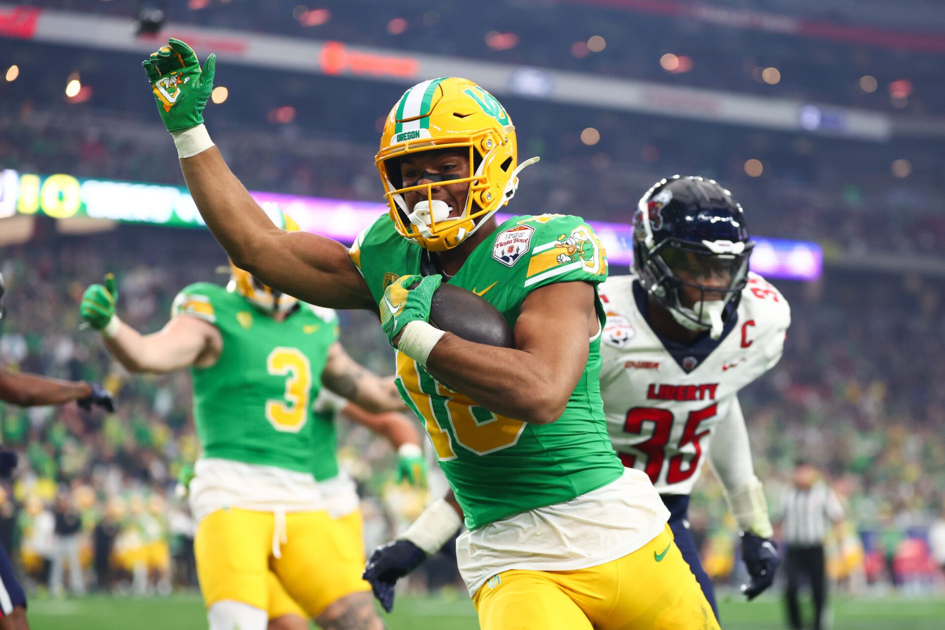 Oregon Ducks tight end Kenyon Sadiq (18) runs in a touchdown against the Liberty Flames during the second quarter of the 2024 Fiesta Bowl at State Farm Stadium.