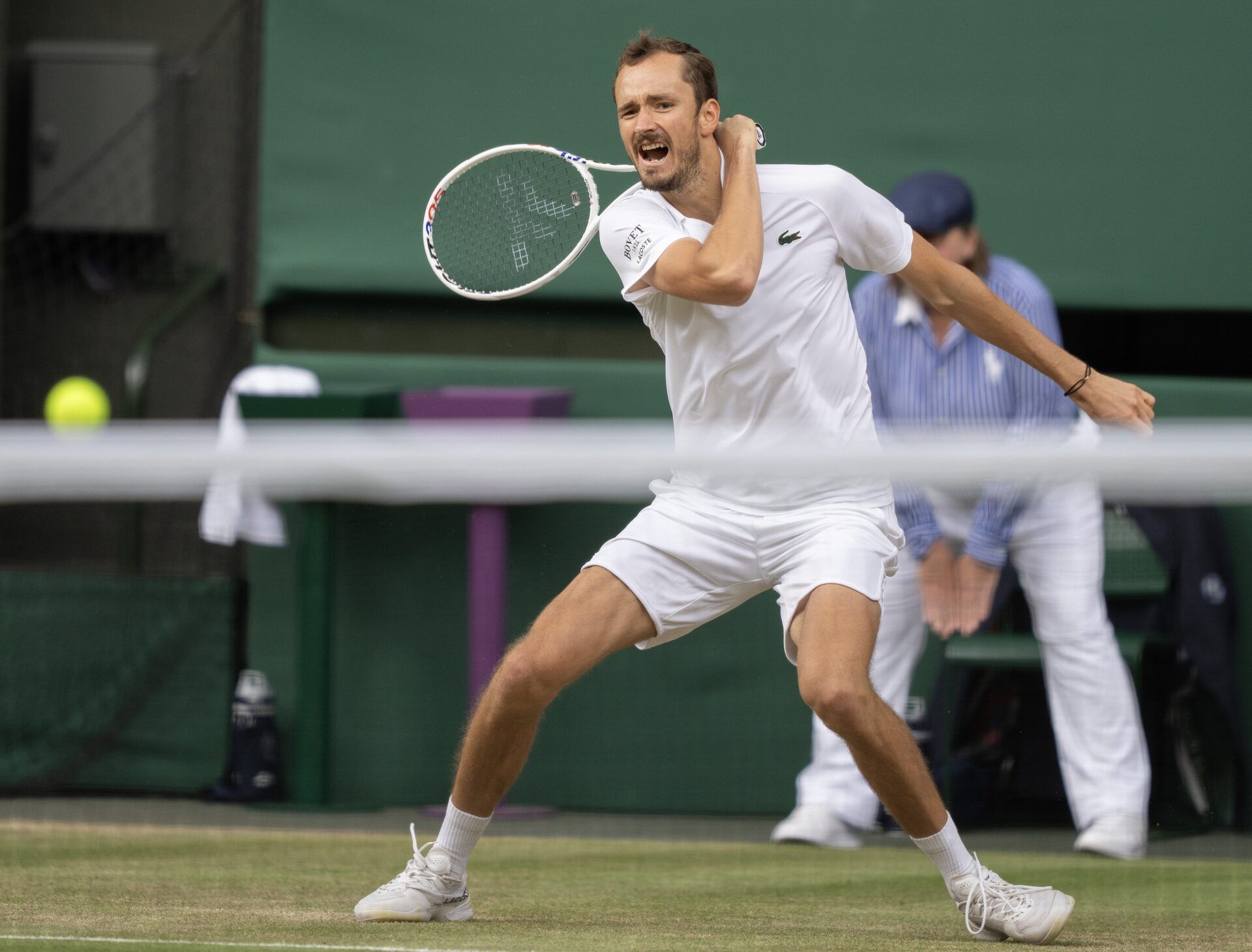 Daniil Medvedev returns a shot during his match against Carlos Alcaraz of Spain on day 12 at All England Lawn Tennis and Croquet Club.