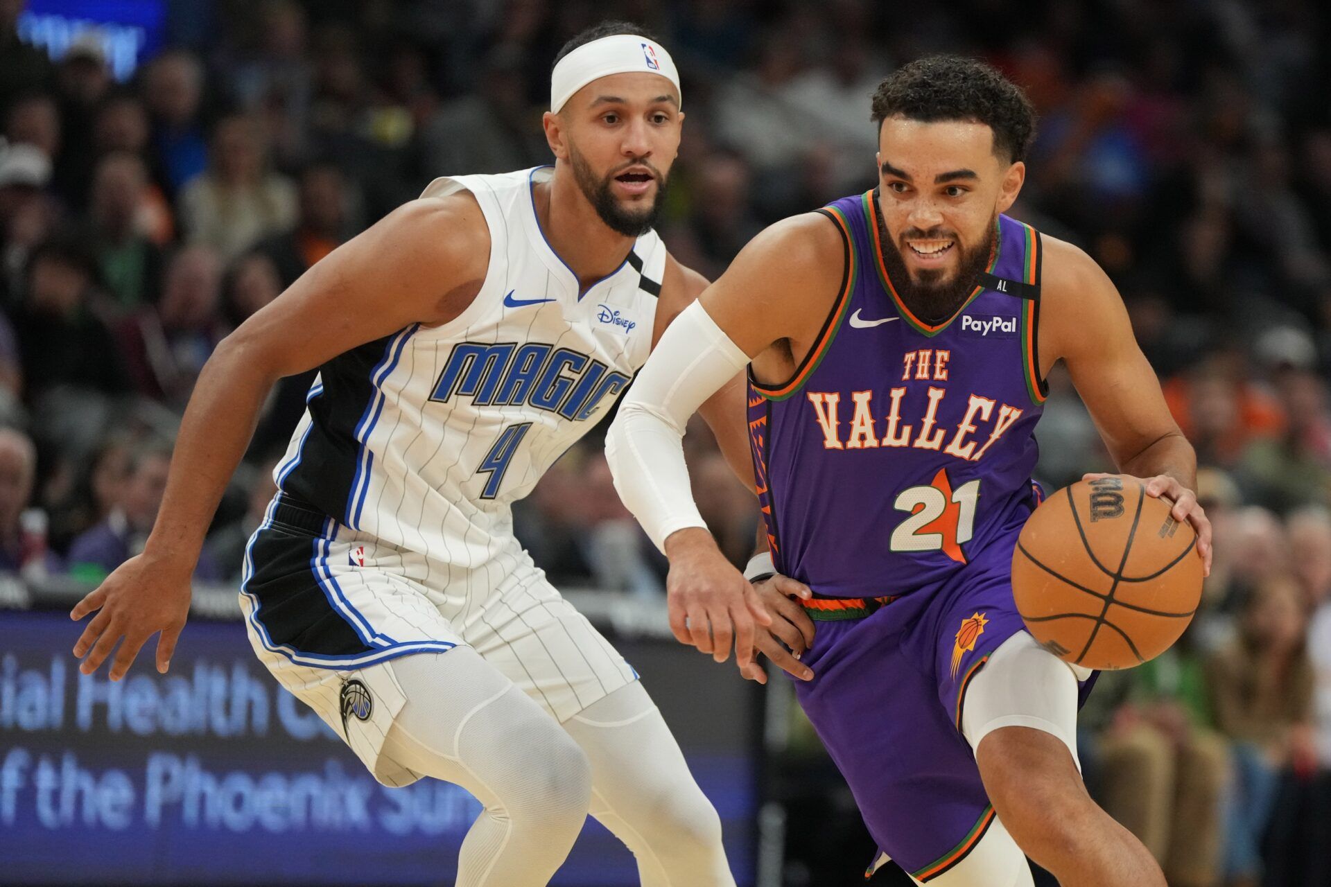 Phoenix Suns guard Tyus Jones (21) drives on Orlando Magic guard Jalen Suggs (4) during the first half of an NBA game at Footprint Center.