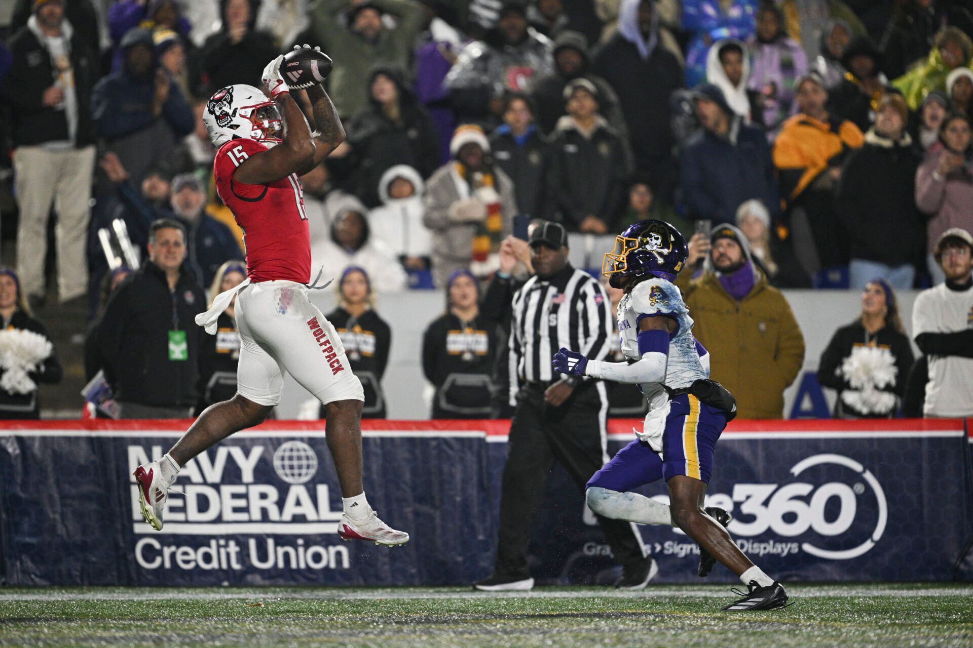 North Carolina State Wolfpack tight end Justin Joly (15) catches a pass for a touchdown as East Carolina Pirates defensive back Dontavius Nash (6) looks on during the second half of the  Go Bowling Military Bowl at Navy-Marine Corps Memorial Stadium.
