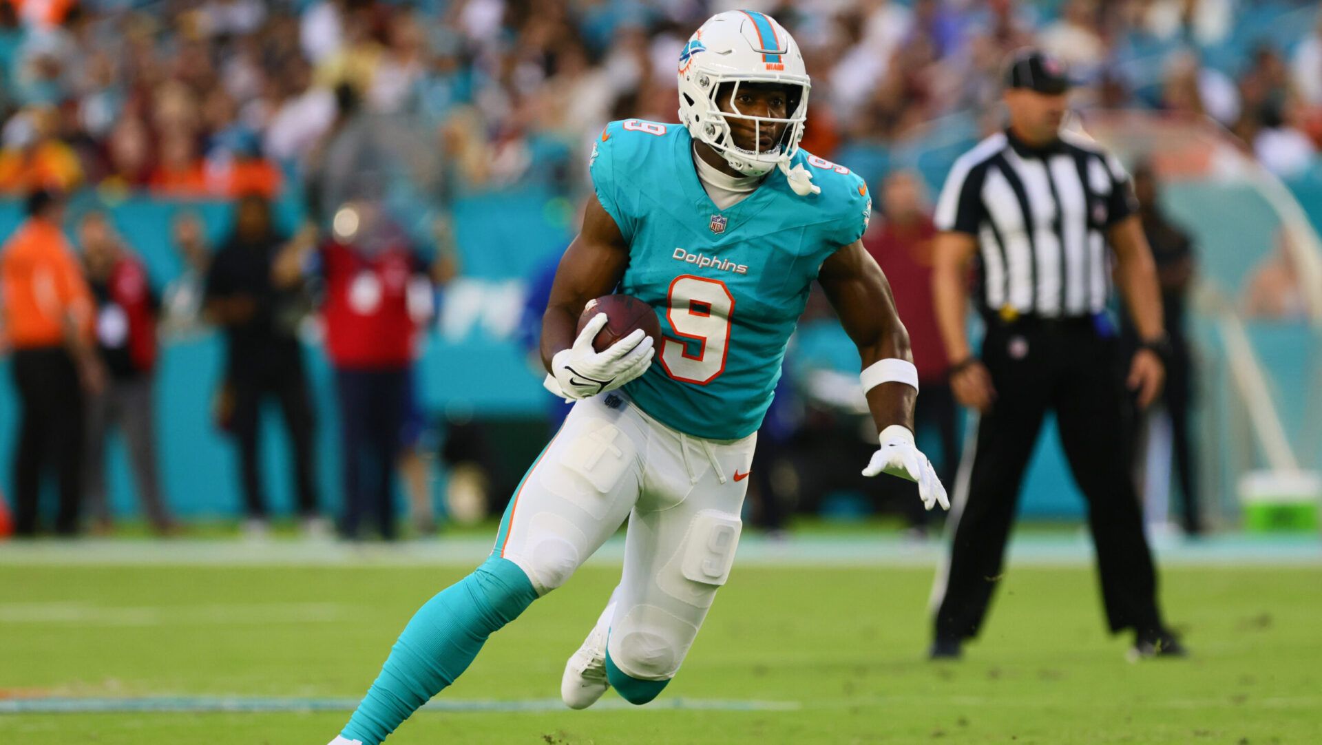 Miami Dolphins tight end Jonnu Smith (9) runs with the football against the Washington Commanders during the first quarter of a preseason game at Hard Rock Stadium.