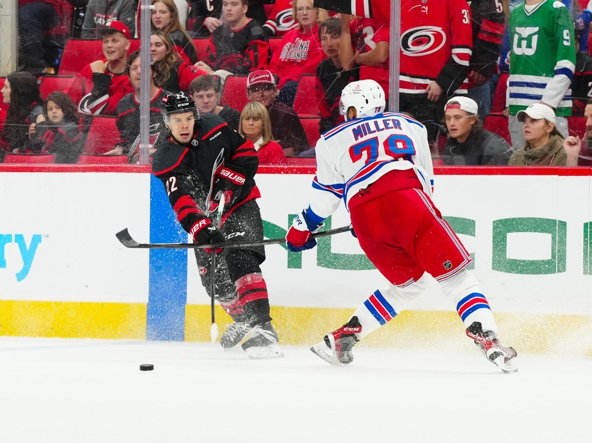 Carolina Hurricanes center Logan Stankoven (22) scores an empty net goal past New York Rangers defenseman K'Andre Miller (79) during the third period at Lenovo Center.