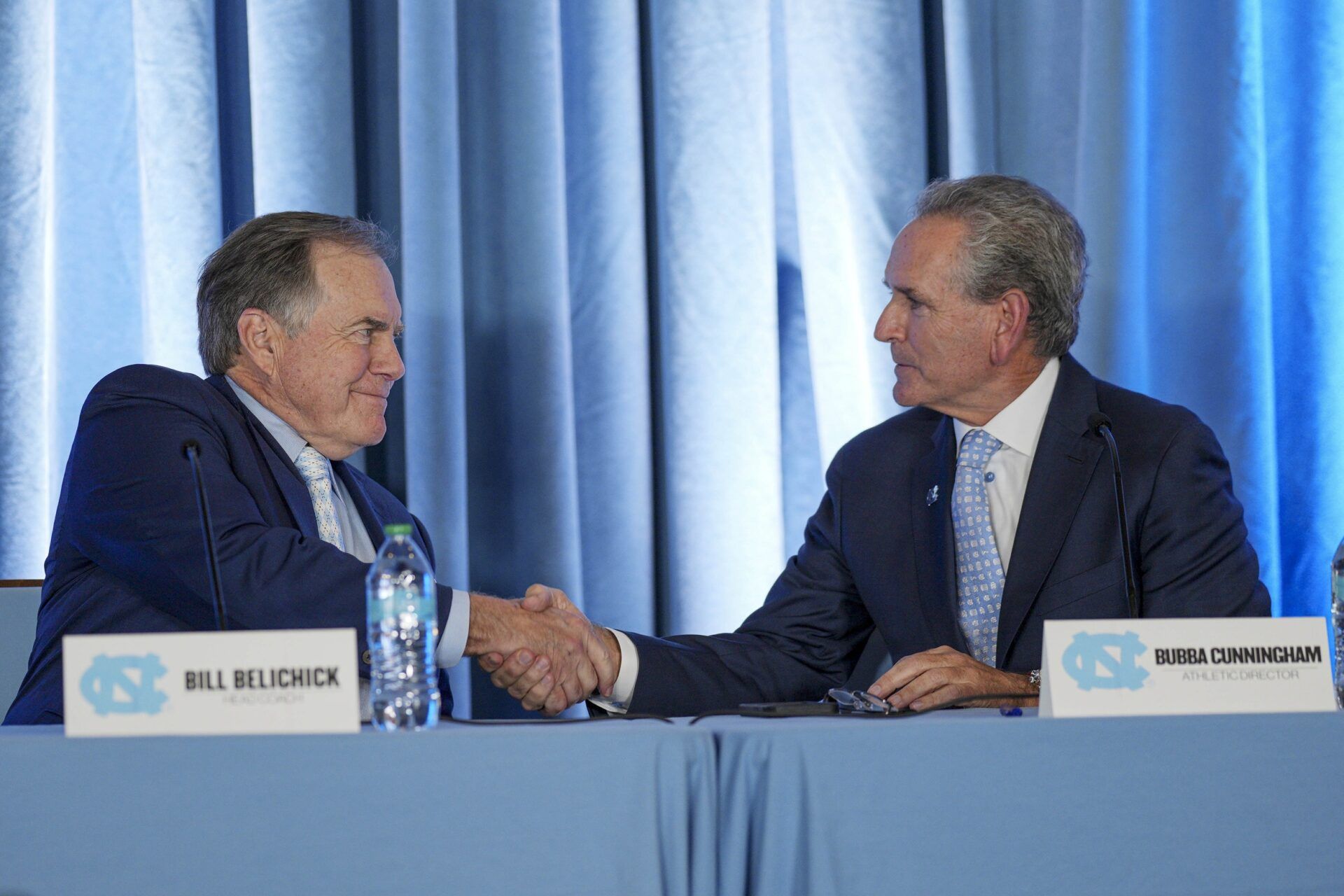 North Carolina Tar Heels new head coach Bill Belichick shakes hands with athletic director Bubba Cunningham at Loudermilk Center for Excellence.