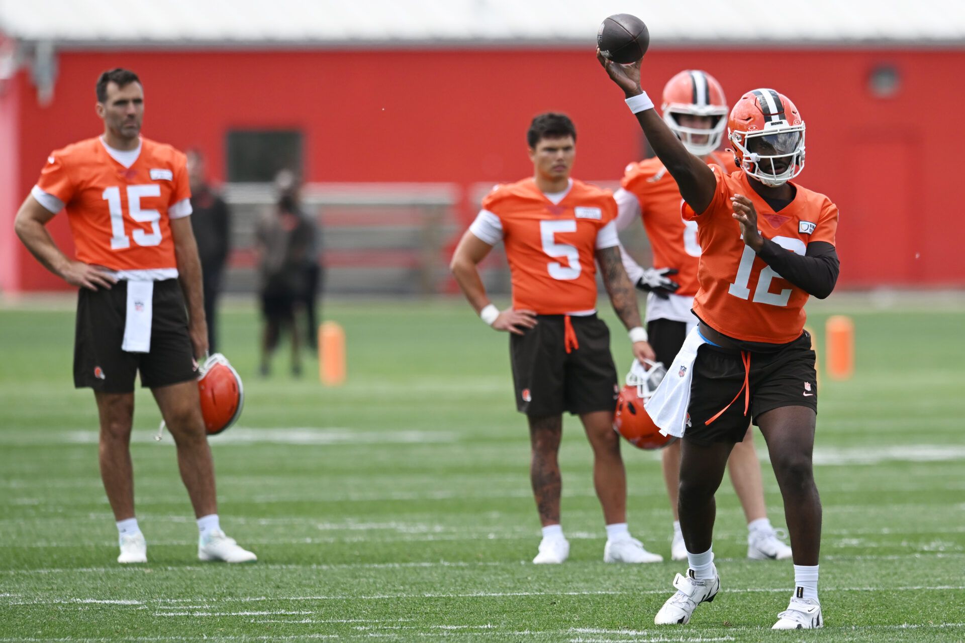 Cleveland Browns quarterback Shedeur Sanders (12) throws a pass as quarterback Joe Flacco (15) and quarterback Dillon Gabriel (5) and quarterback Kenny Pickett (8) look on during minicamp at CrossCountry Mortgage Campus.