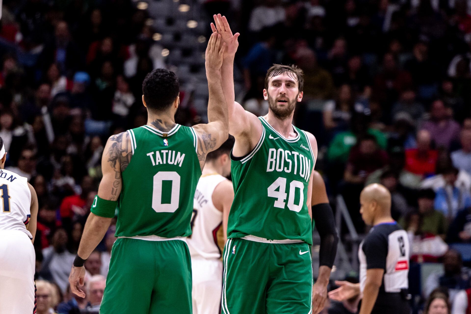 Boston Celtics center Luke Kornet (40) slaps hands with forward Jayson Tatum (0) after dunking the ball against the New Orleans Pelicans during the second half at Smoothie King Center.