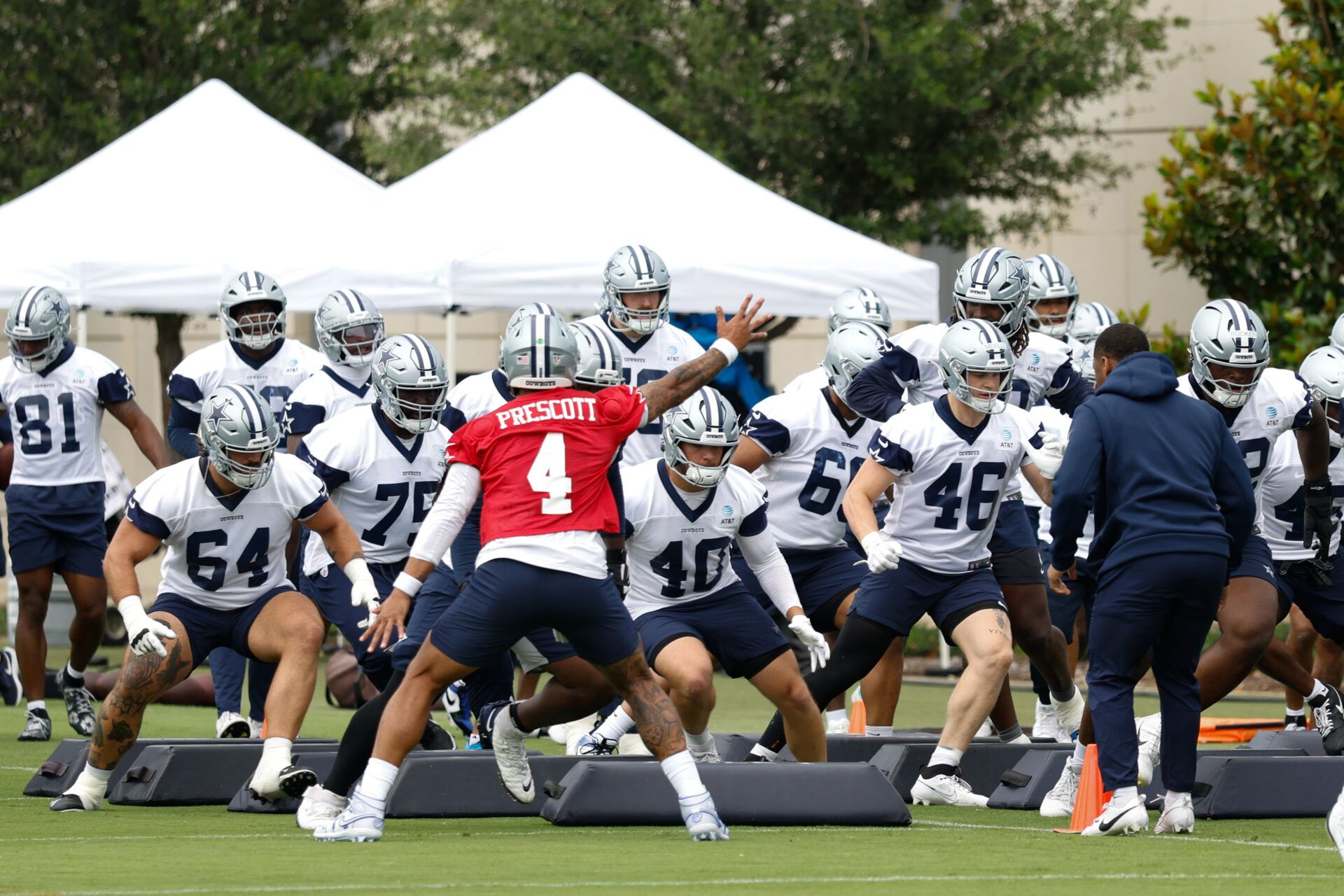 Dallas Cowboys quarterback Dak Prescott (4) leads teammates through a drill at the Ford Center at the Star Training Facility in Frisco, Texas.