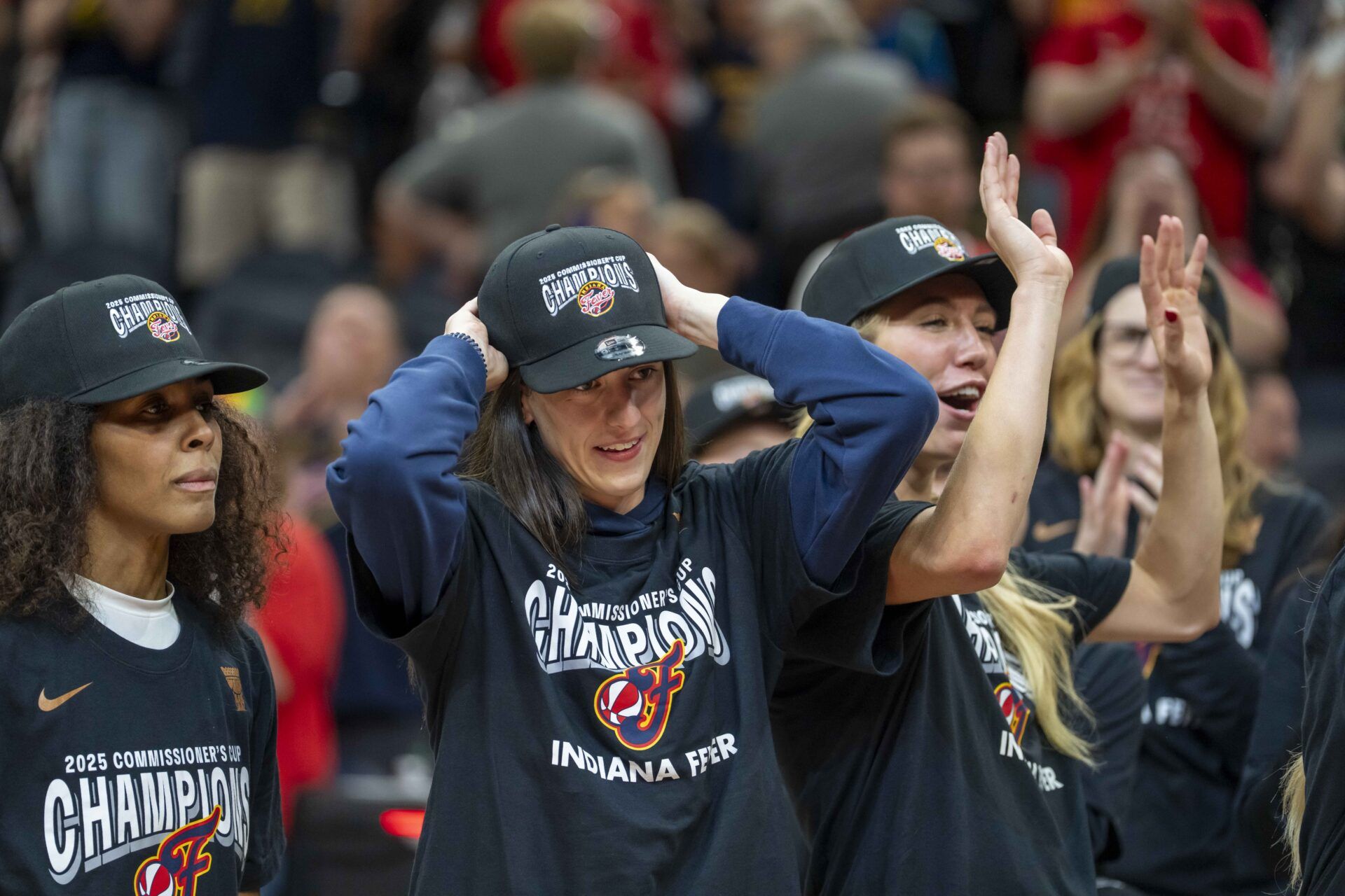 Indiana Fever guard Caitlin Clark (22) puts on a Commissioner's Cup Champions hat after defeating the Minnesota Lynx at Target Center.